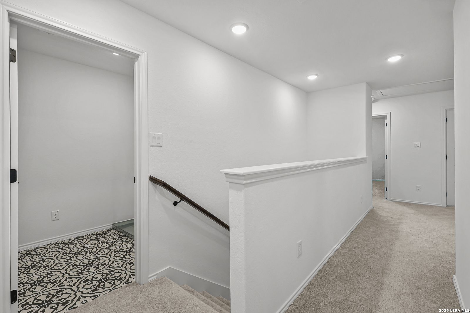 Bright upstairs hallway with carpeted flooring leading to bedrooms in The Gillian C floor plan, Meadows at Oak Creek.
