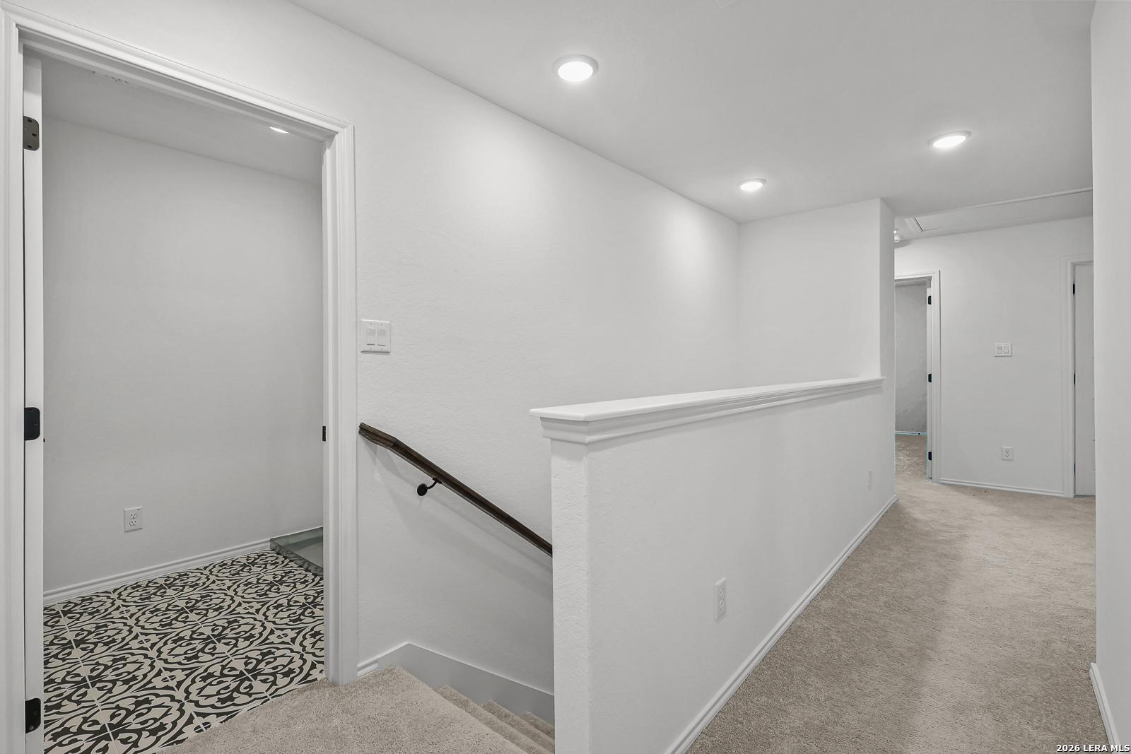 Bright upstairs hallway with carpeted flooring leading to bedrooms in The Gillian C floor plan, Meadows at Oak Creek.