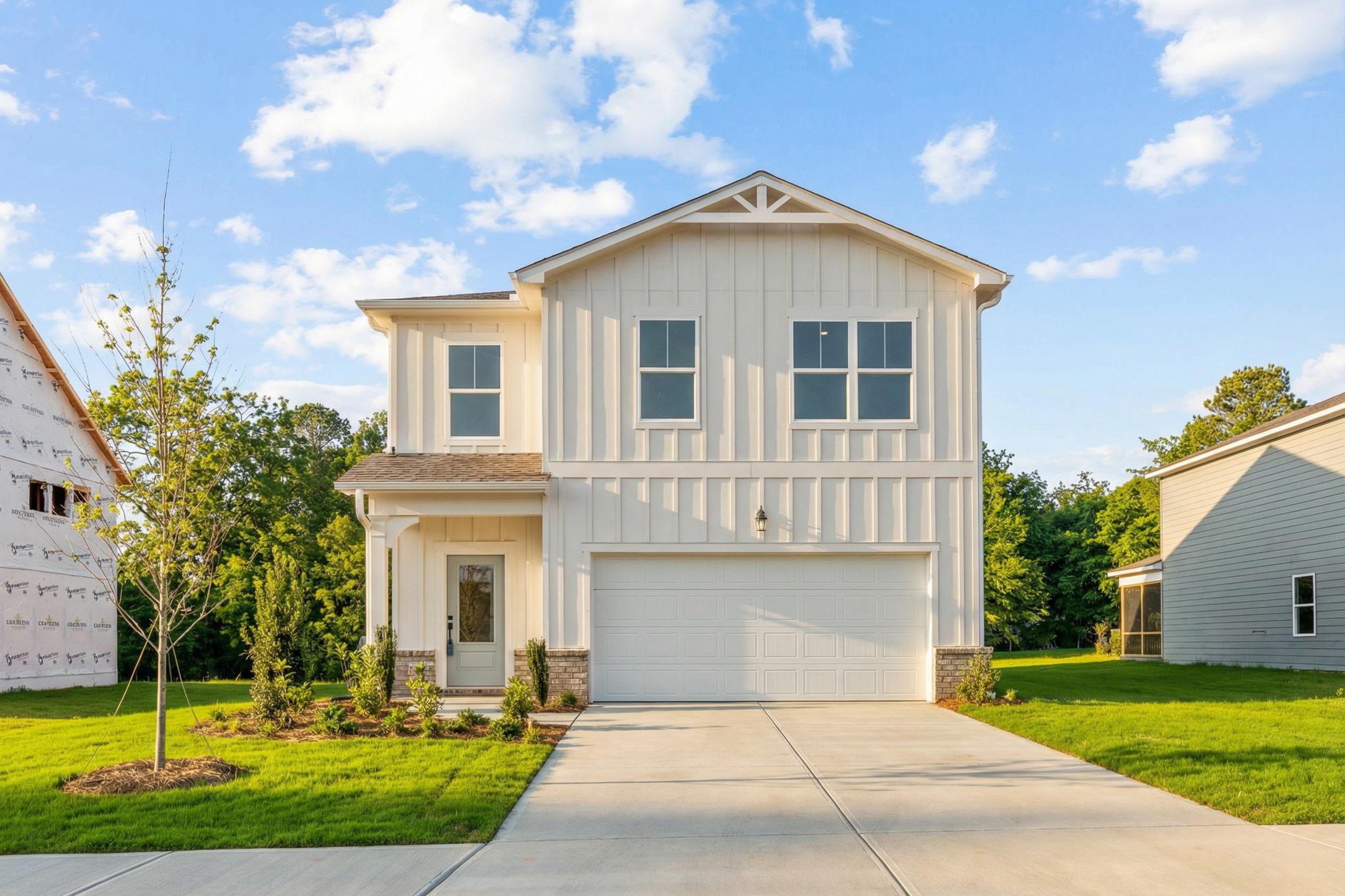 Modern farmhouse home exterior at Links Crossing in Auburn Alabama with board and batten siding, covered porch, and two-car garage