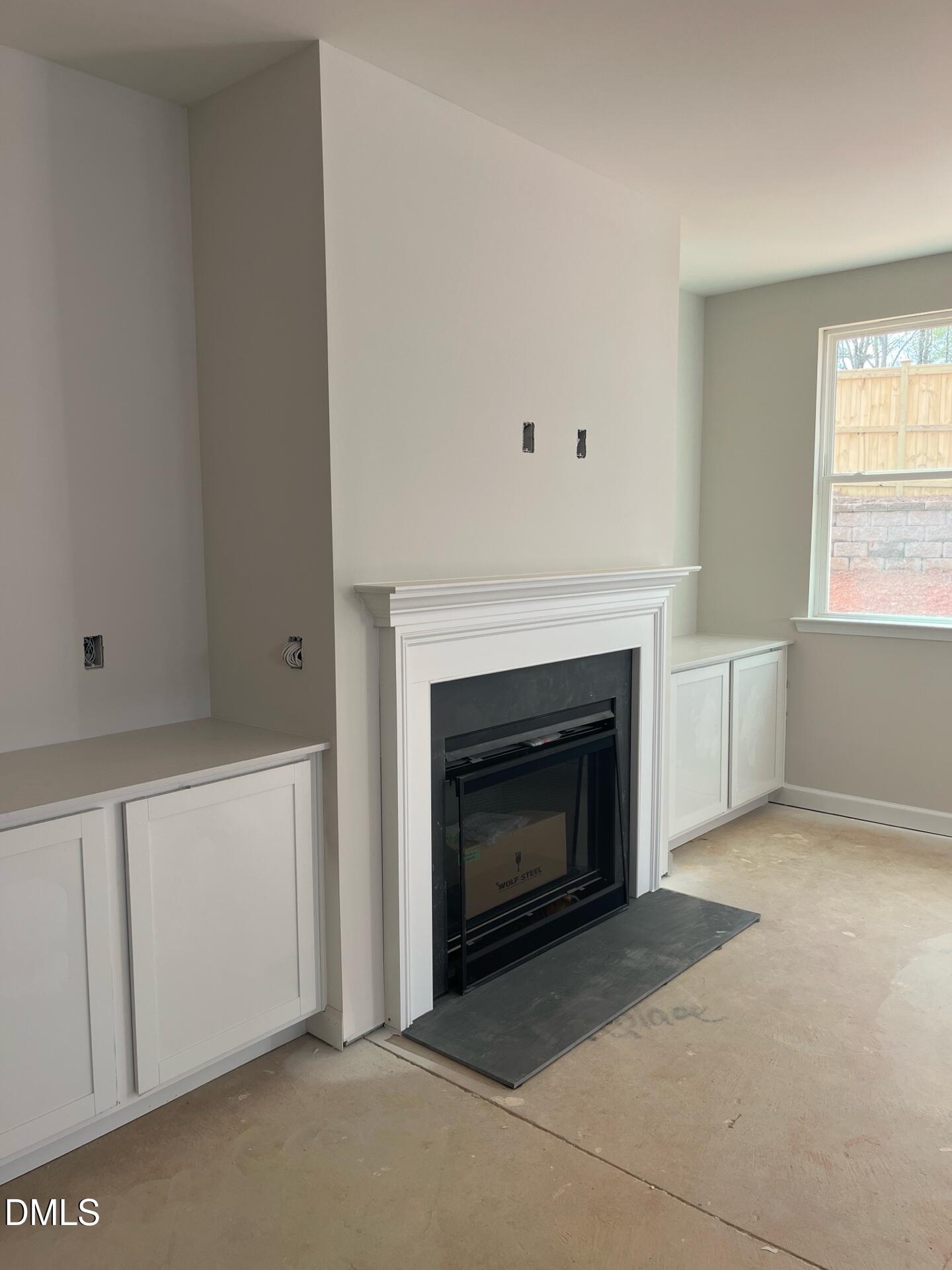 Modern white fireplace with built-in cabinets in family room of Davidson Homes Ashport G, Wake Forest NC