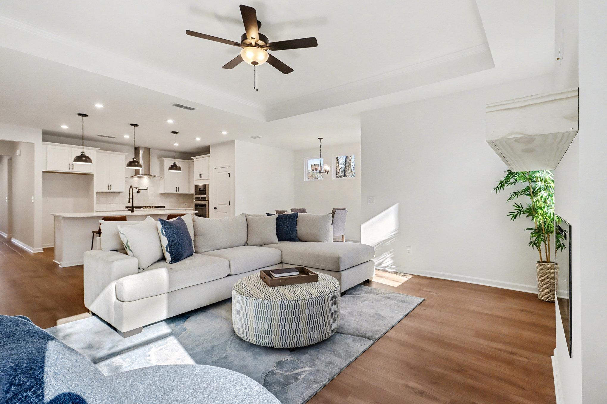 Cozy family room featuring electric fireplace, hardwood floors, French doors, and natural light in Davidson Homes The Daphne B, Loganville, GA