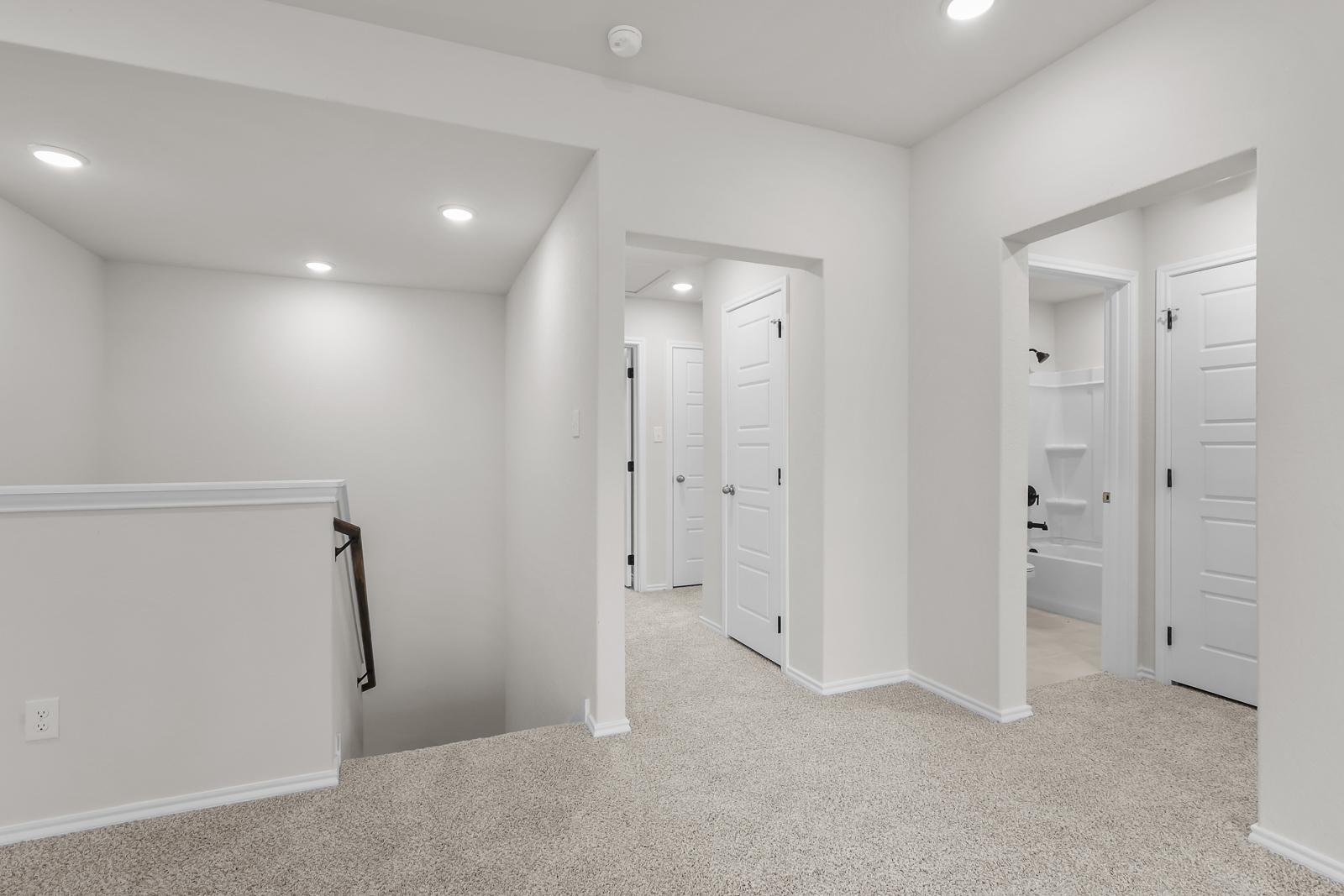 Second-floor landing and hallway of The Sequoia C, featuring plush carpeting and access to bedrooms and a full bathroom.