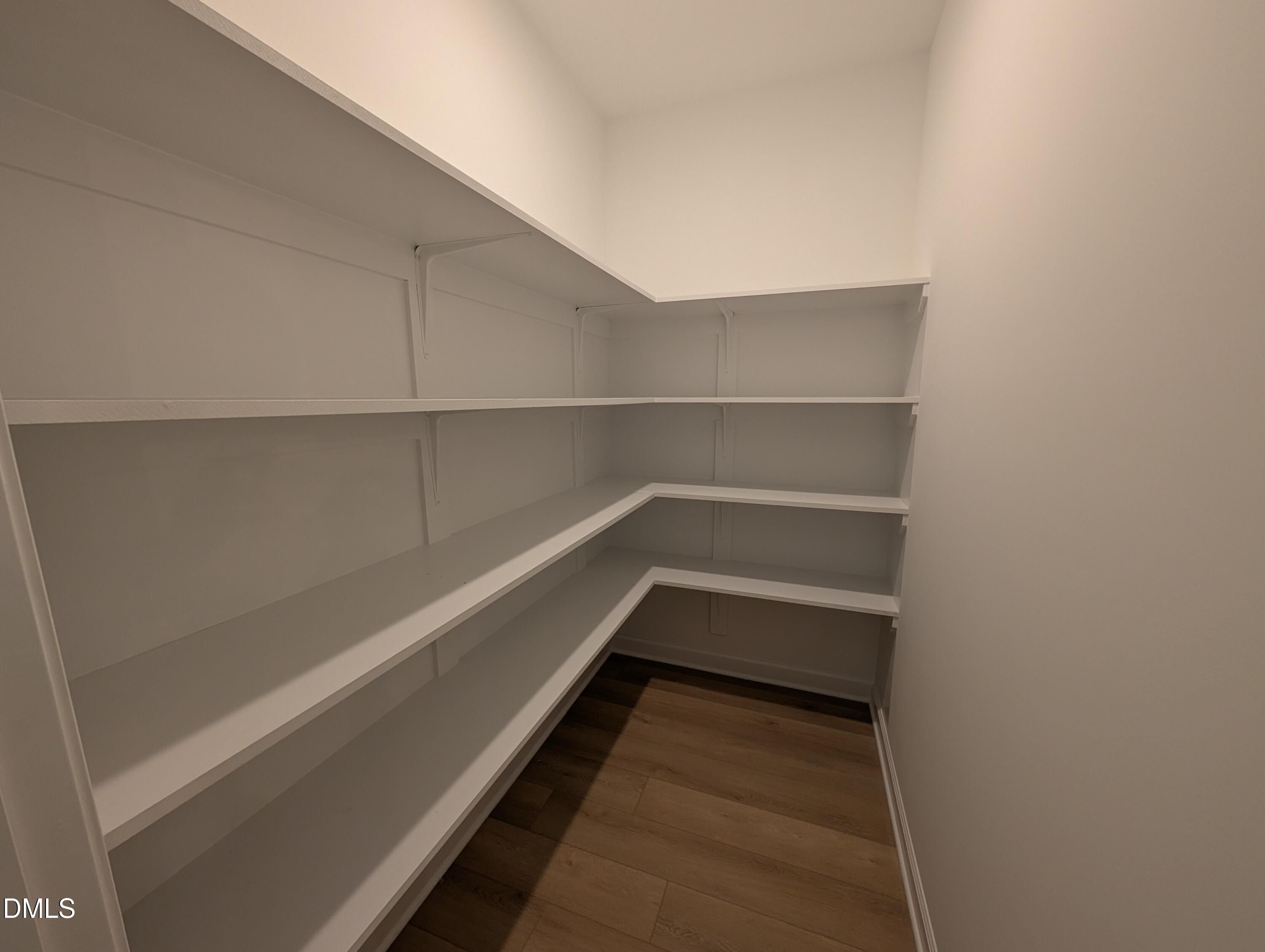 Walk-in pantry with white wrap-around shelving in The Aspen B floor plan by Davidson Homes in Wendell Ridge, North Carolina.