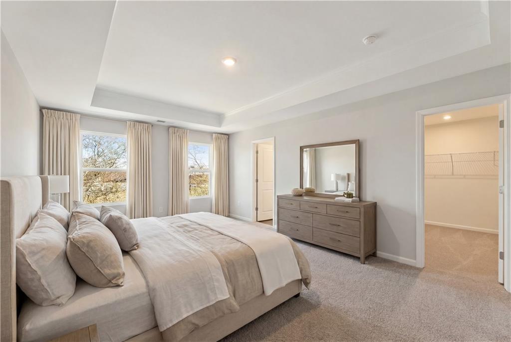 Elegant master bedroom with king bed, tray ceiling, walk-in closet in Davidson Homes The Marion A, Lake Shore, Winder, Georgia