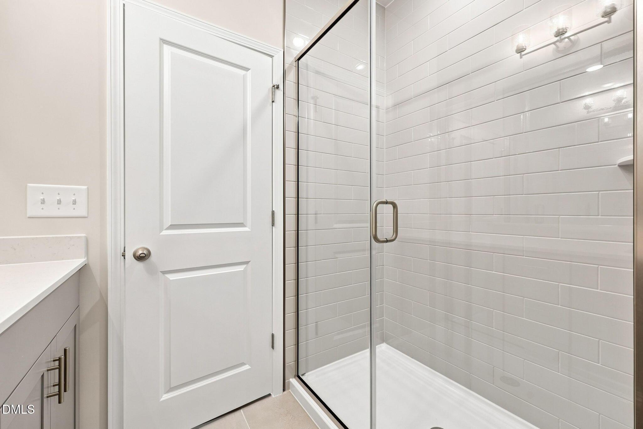 Modern walk-in shower with subway tile in The Magnolia B floor plan at Retreat at North Main in Lillington, NC.