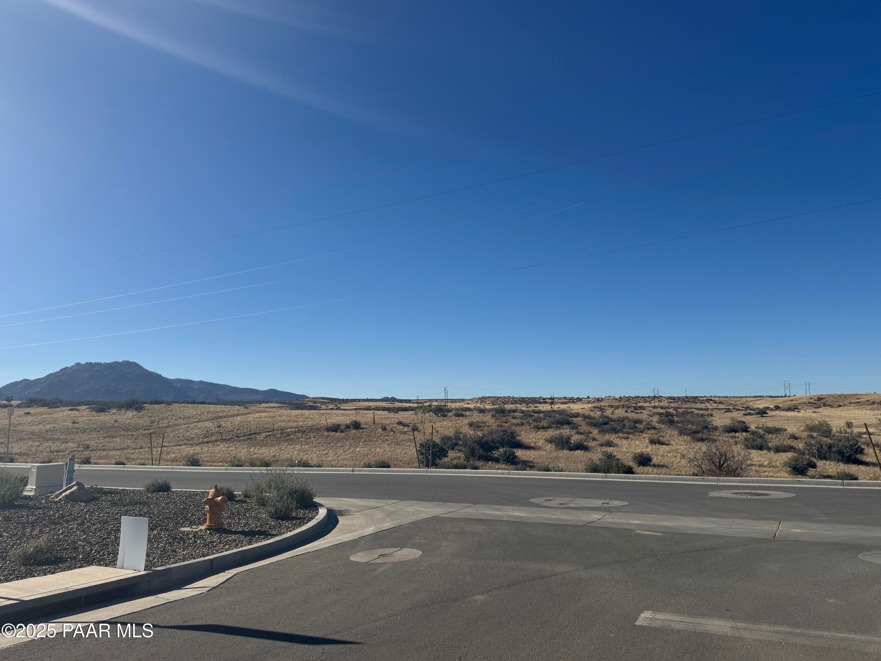 Scenic desert street with mountain backdrop, fire hydrant, and shrubs in Westwood, Prescott, Arizona, Davidson Homes The Summit A site