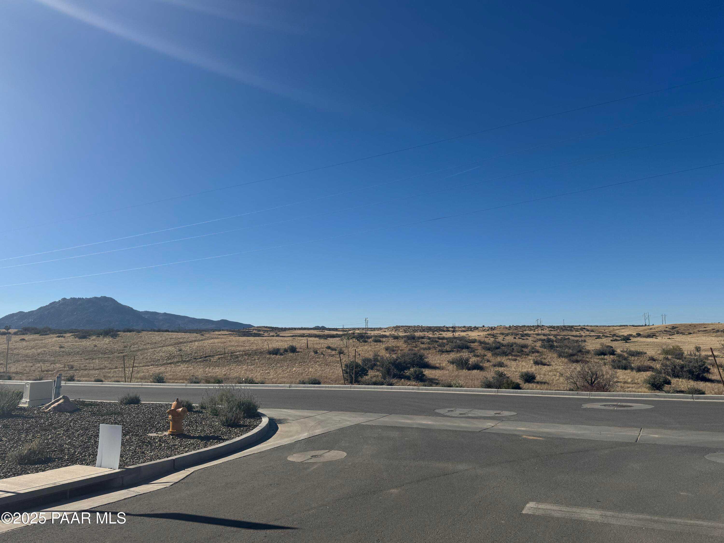 Scenic desert street with mountain backdrop, fire hydrant, and shrubs in Westwood, Prescott, Arizona, Davidson Homes The Summit A site