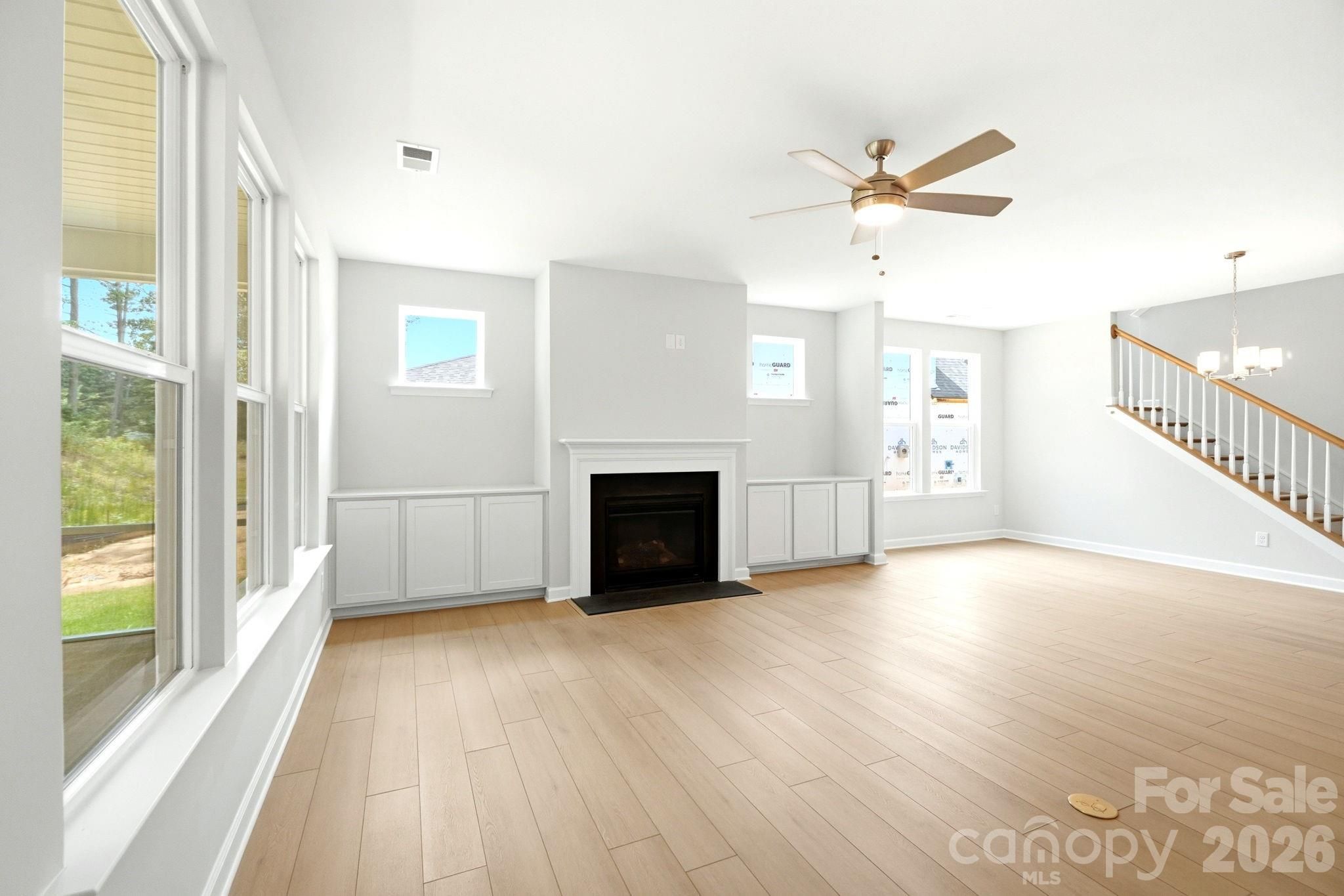 Bright living room with fireplace and built-in cabinets in The Magnolia B floor plan at Windgate, Mooresville, NC.