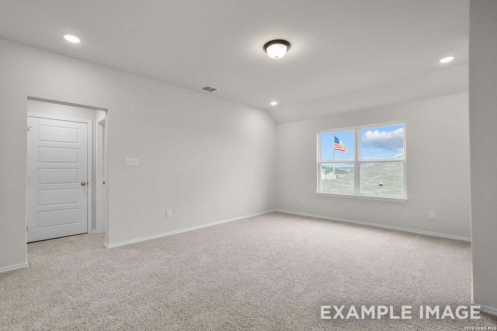 Spacious upstairs bedroom with plush carpet and large window in The Sequoia C floor plan at Royal Crest, San Antonio.