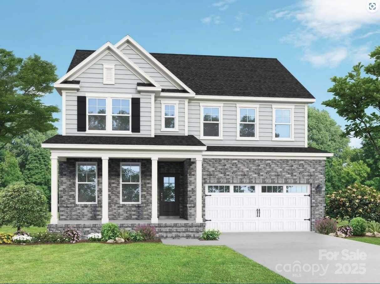 Two-story gray Chestnut F home with brick base, covered porch, 2-car garage, lush landscaping in Enclave at Belmont, NC