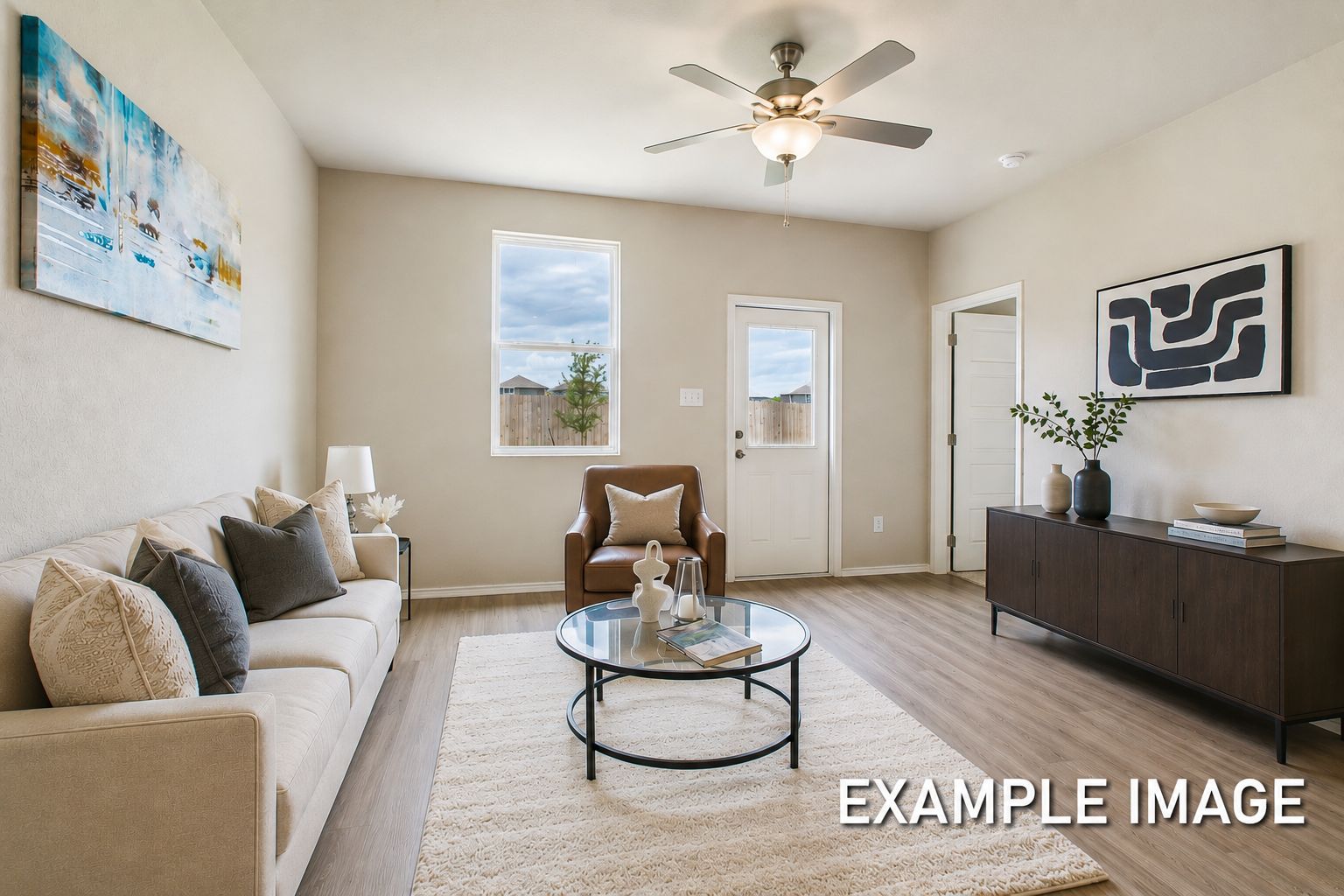 Bright, open-concept living area in The Comal by Davidson Homes featuring modern decor, a glass coffee table, and sofa.