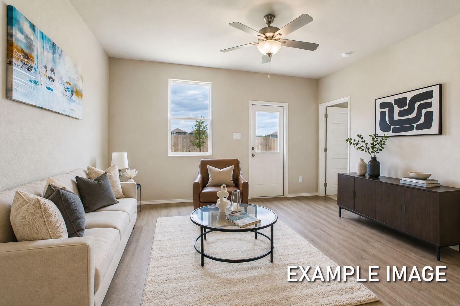 Bright, open-concept living area in The Comal by Davidson Homes featuring modern decor, a glass coffee table, and sofa.