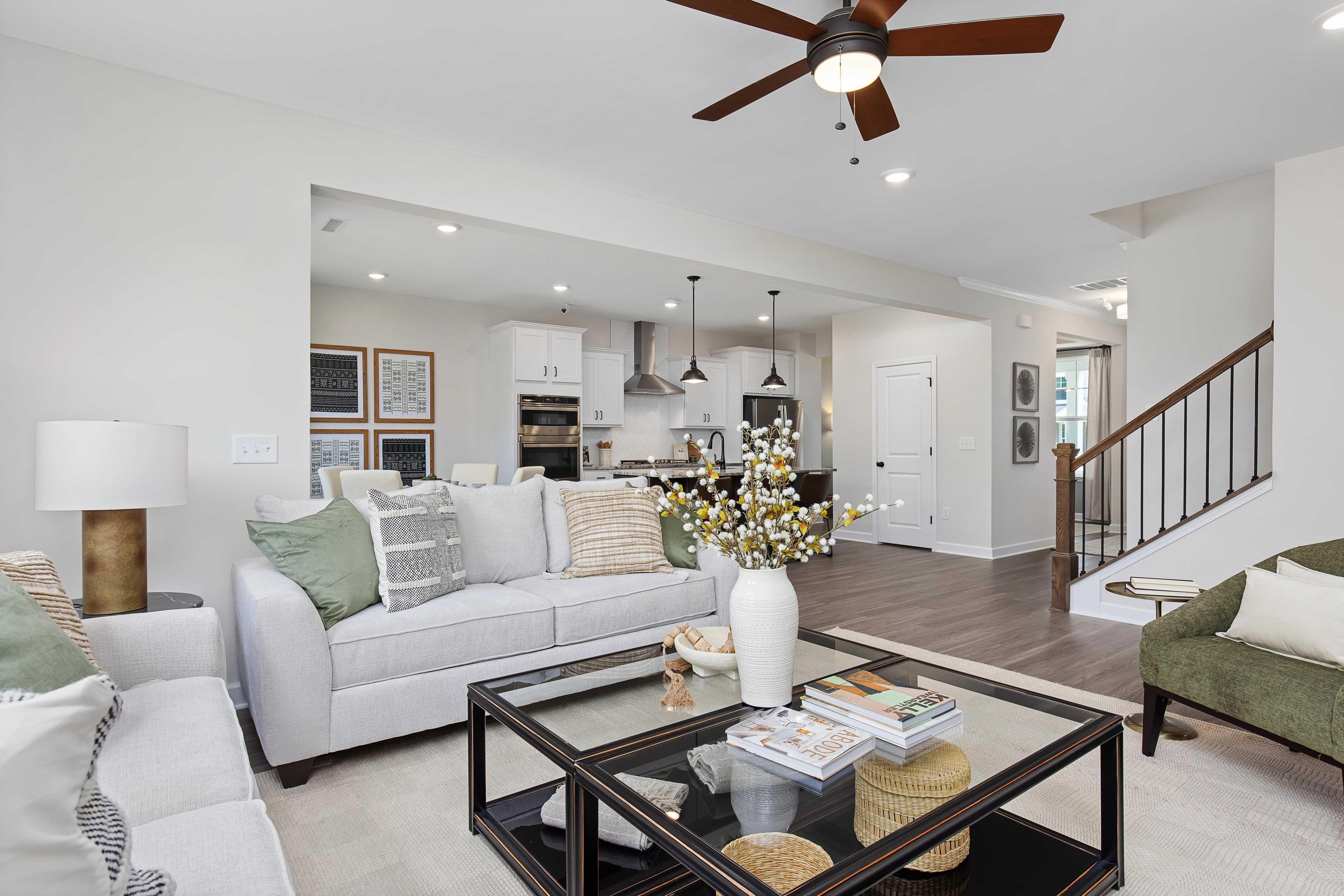 Spacious open-concept living room at Woodland Crossing in Zebulon NC by Davidson Homes with hardwood floors and neutral decor