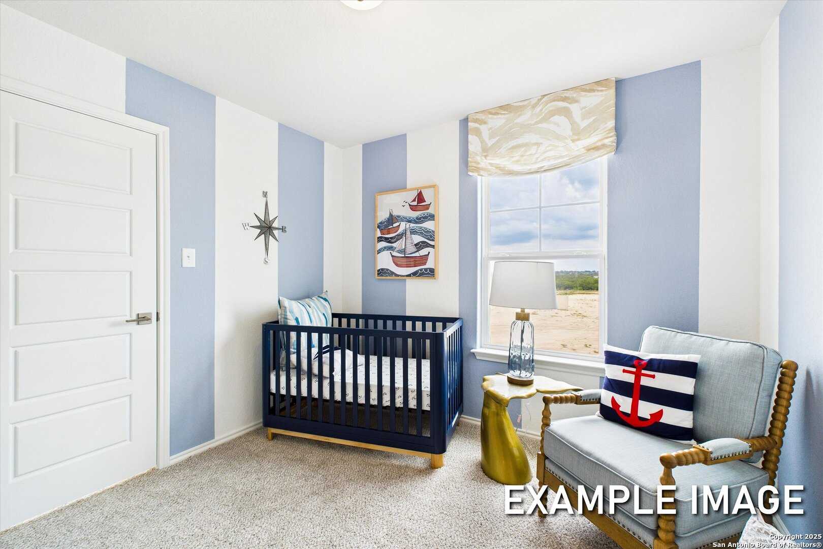 Cozy nautical nursery with blue striped walls, wooden crib, rocking chair, and boat artwork in Davidson Homes The Brazos C, Agave, San Antonio