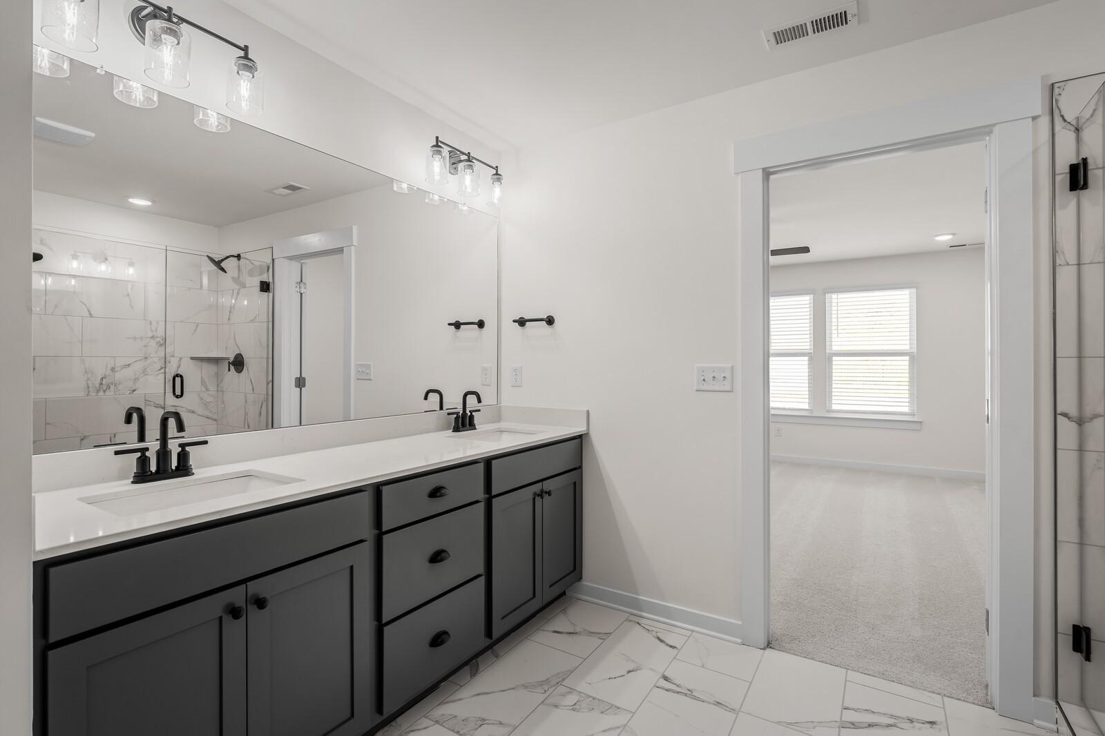 Modern master bathroom with dual vanity and walk-in shower in The Willow floor plan at Woods Crossing in Gallatin, TN.