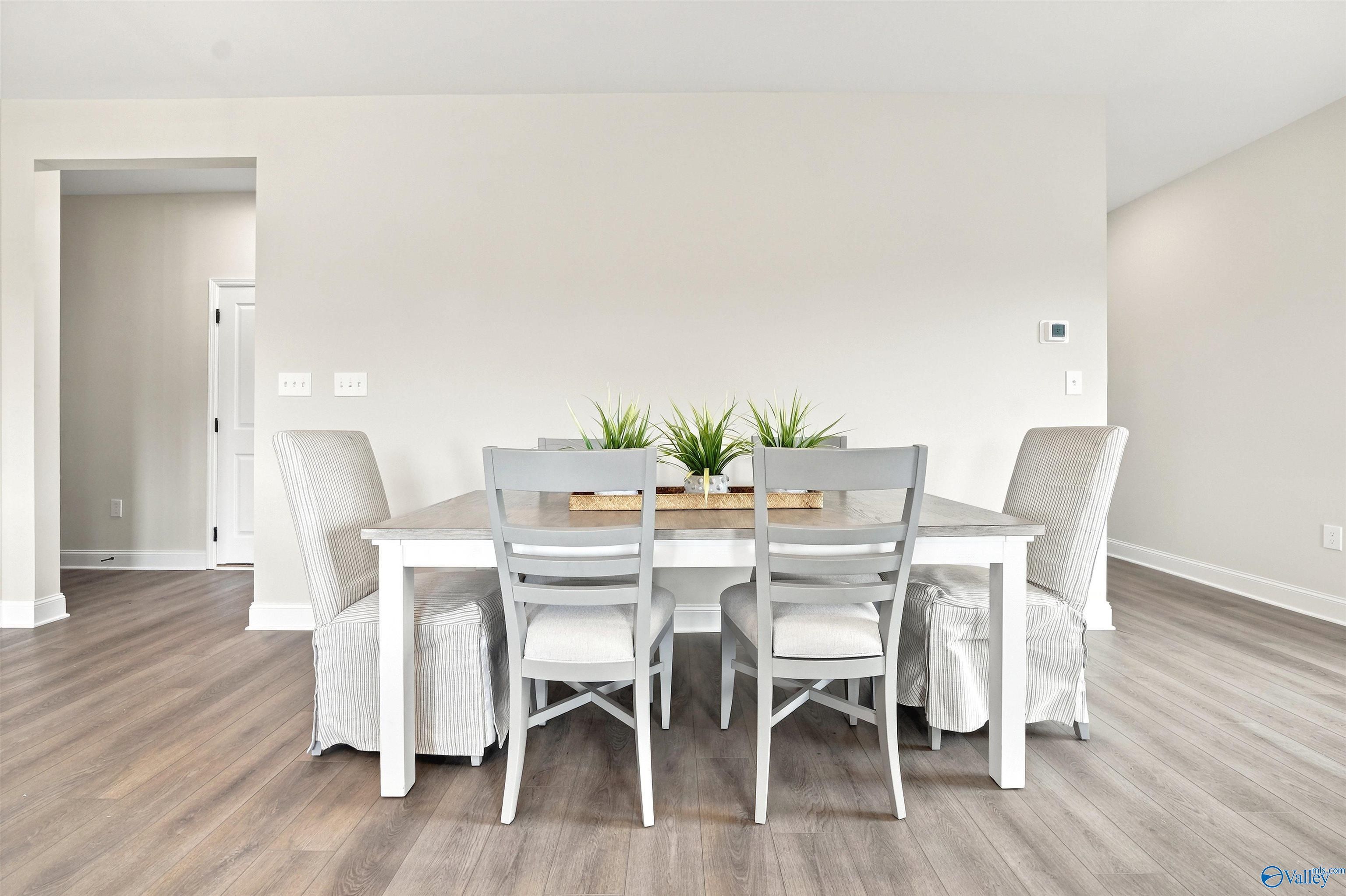 Bright dining area with modern table and chairs in The Burton B floor plan at Heritage Lakes, New Market, Alabama.