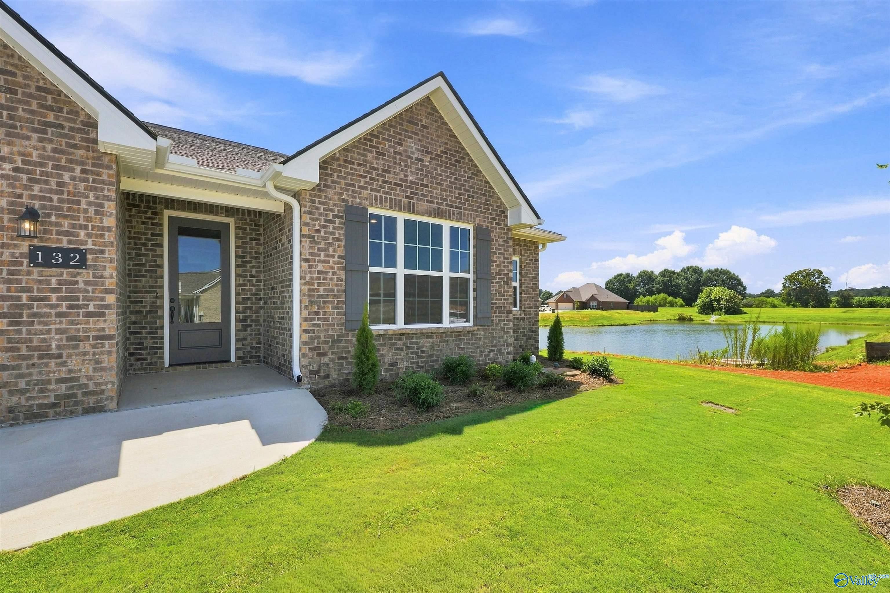 The Montgomery floor plan by Davidson Homes in Kendall Downs, Toney, Alabama featuring brick exterior and waterfront view.