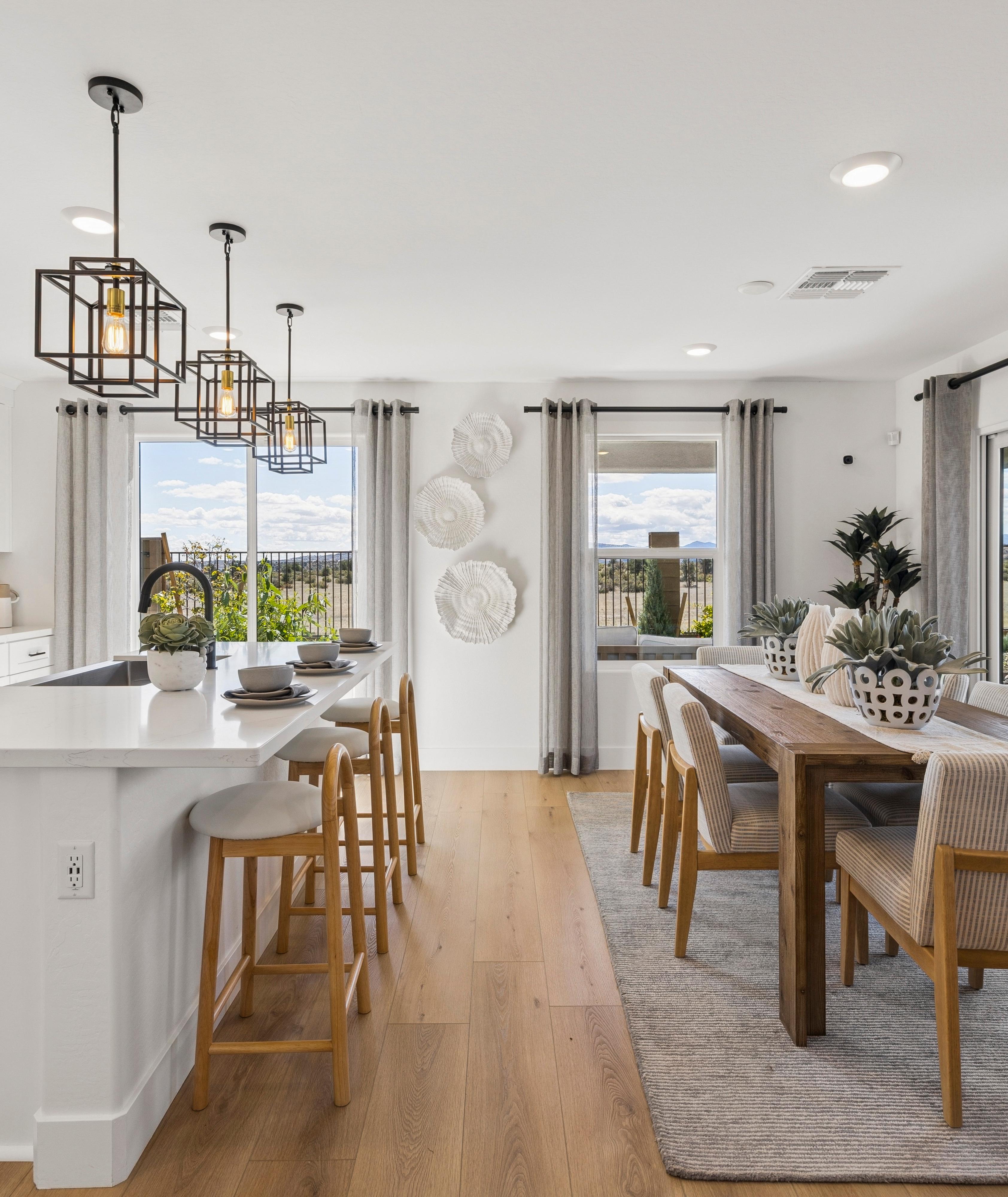 Spacious modern kitchen in South Ranch Southern Collection Prescott AZ with white quartz island, stainless appliances, pendant lighting and desert views