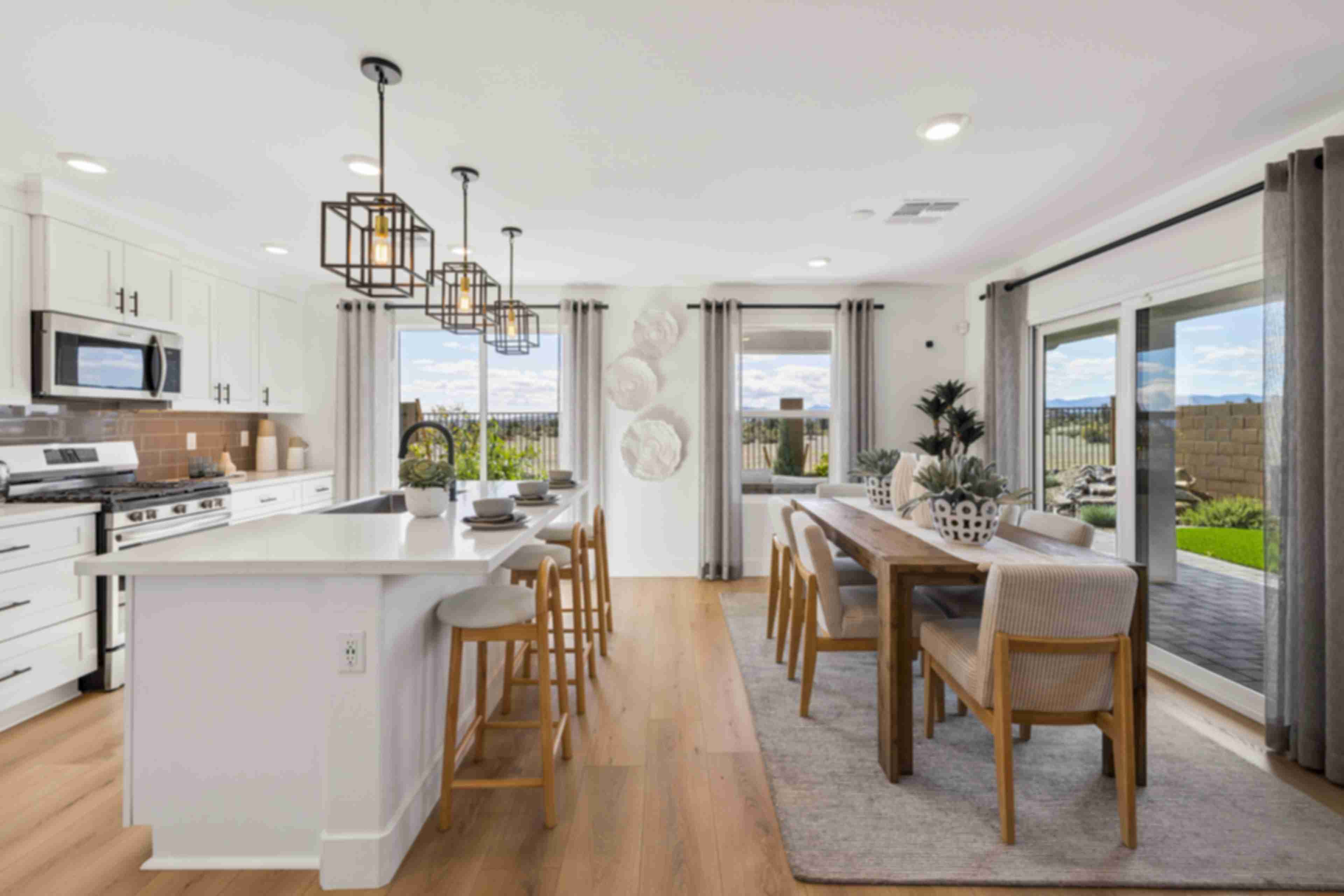 Spacious modern kitchen in South Ranch Southern Collection Prescott AZ with white quartz island, stainless appliances, pendant lighting and desert views