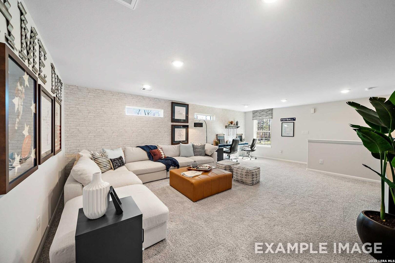 Spacious loft living area with white brick accent wall in The San Marcos F floor plan at Rayburn Valley, San Antonio.