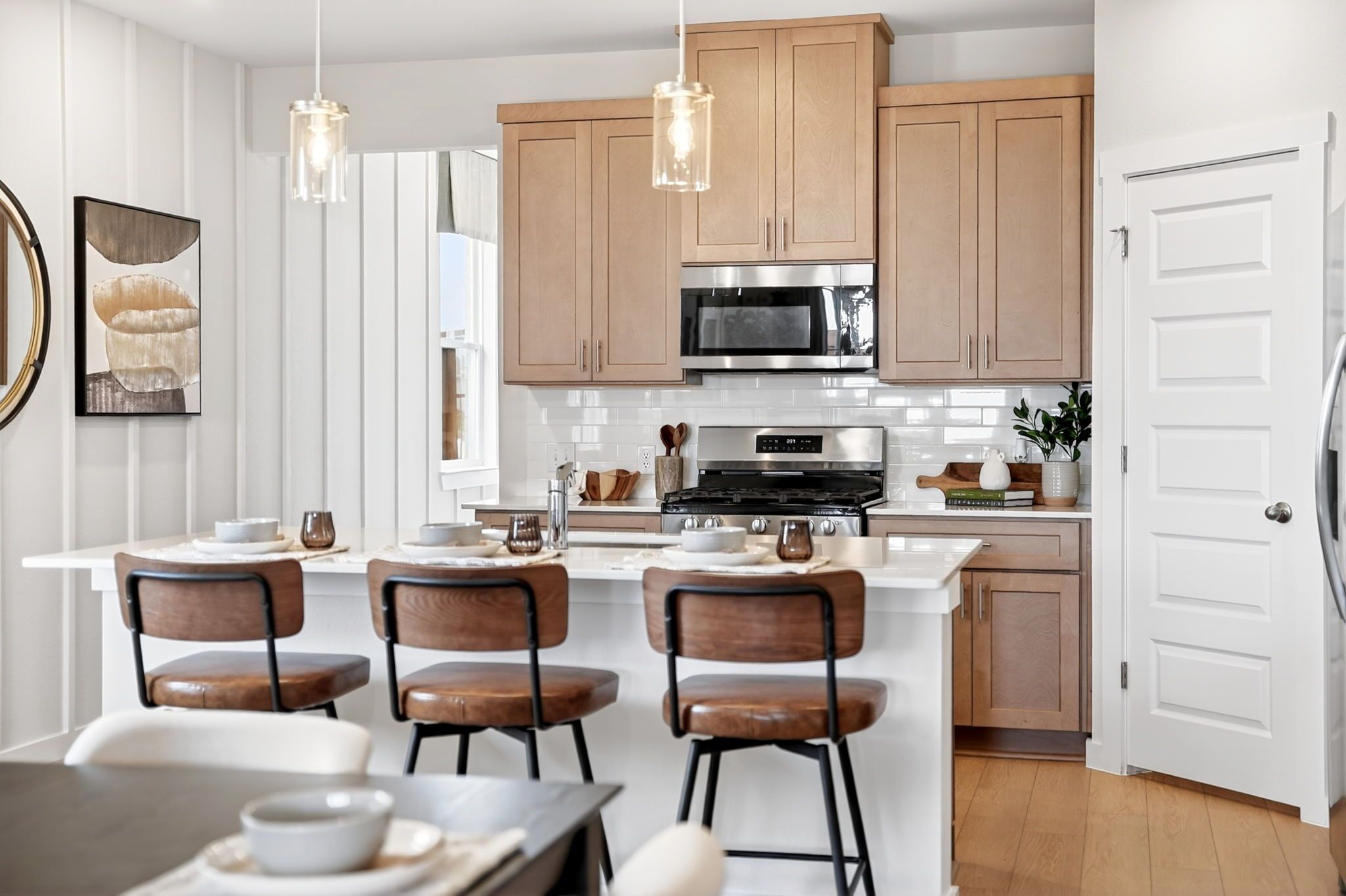 Modern kitchen with light oak cabinets, white quartz island, subway tile backsplash in Heartland Texas home by Davidson Homes