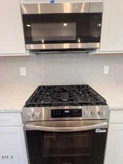 Modern kitchen with stainless steel gas range and microwave in The Willow C floor plan at Woodland Crossing, Zebulon, NC.