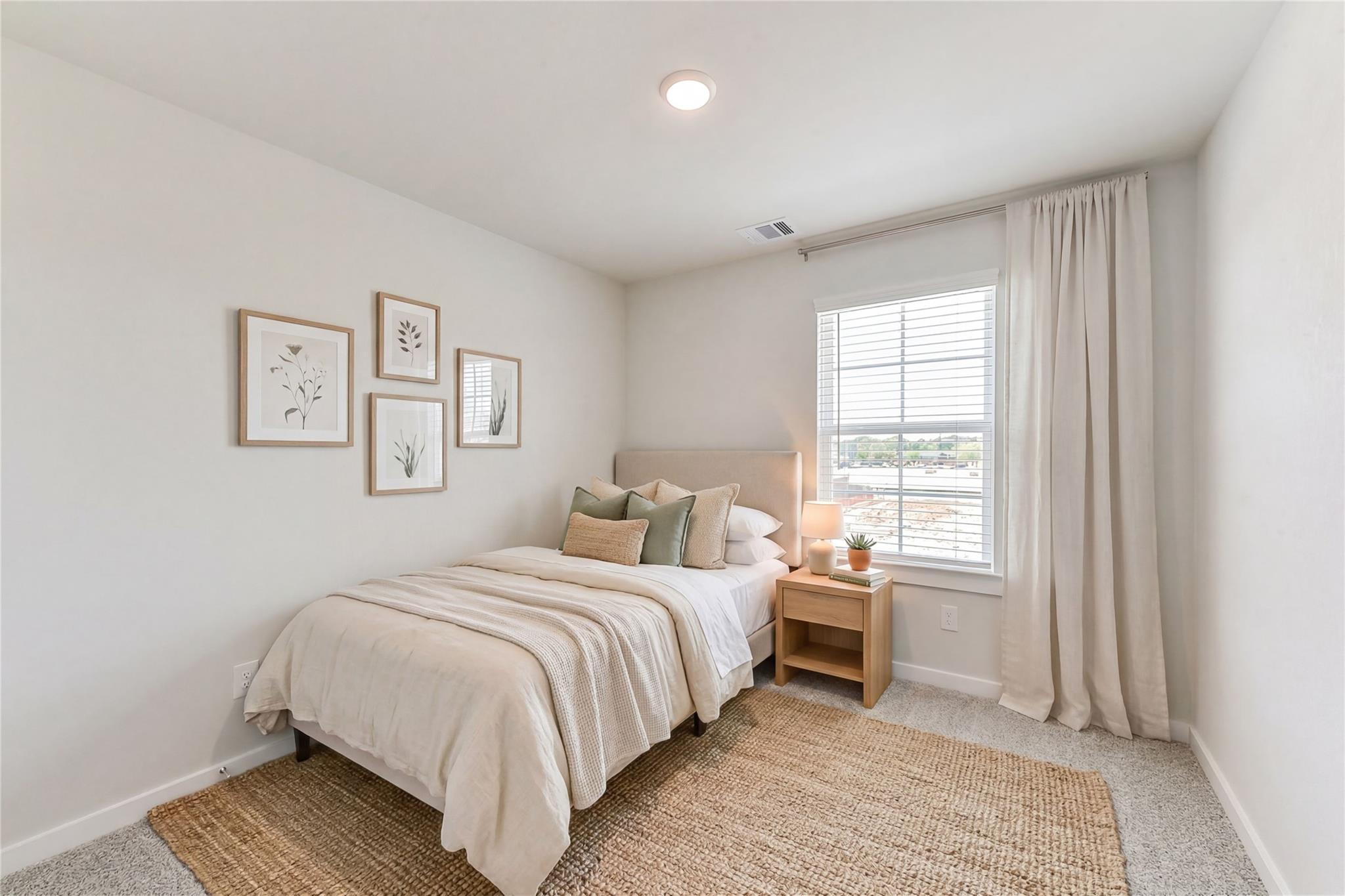 Cozy secondary bedroom with neutral twin bed, green pillows, botanical art, nightstand plant, and window curtains in Davidson Homes The Brazos E, Magnolia, Texas
