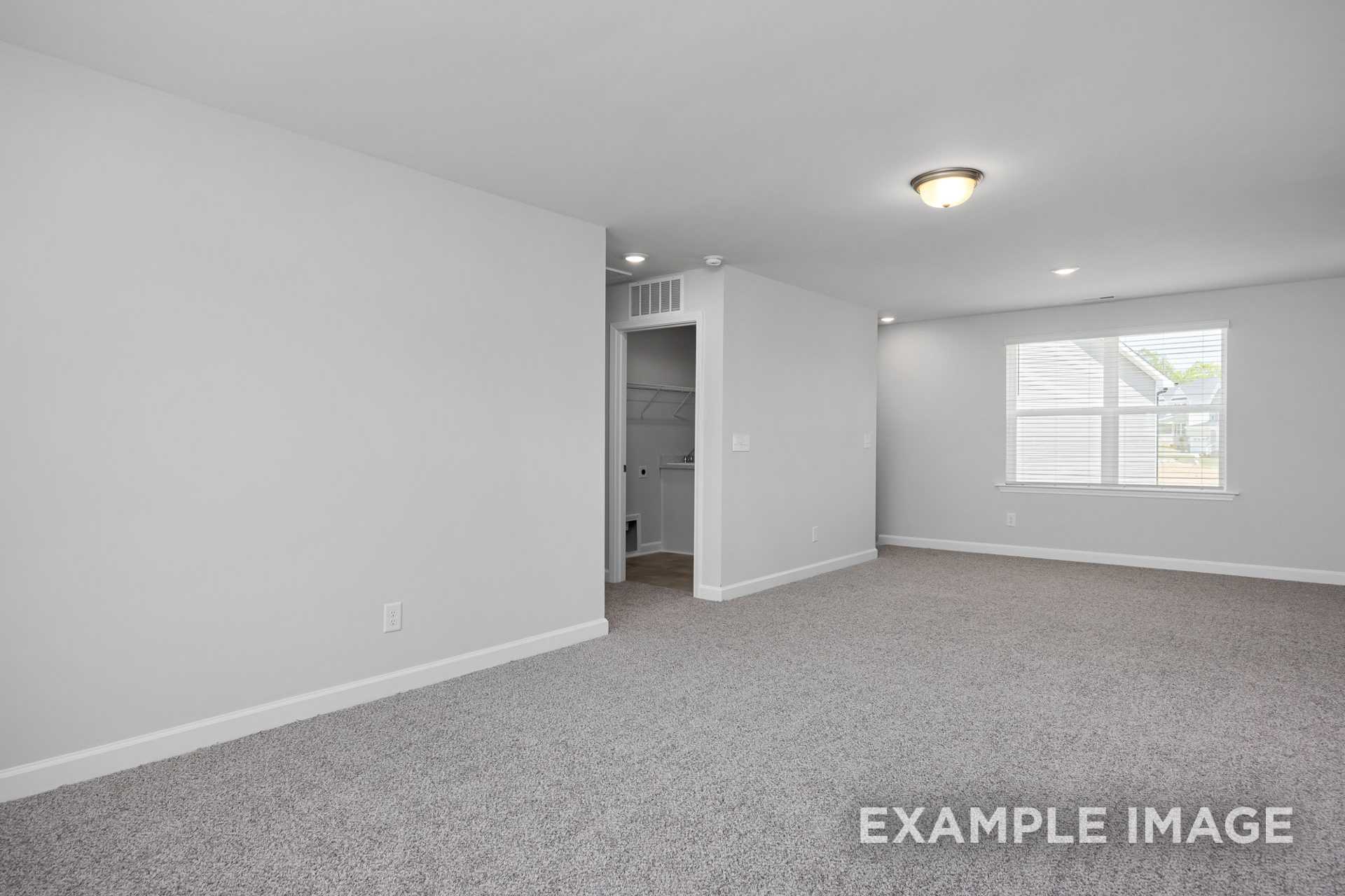 Spacious upper-floor master bedroom in The Preston B with gray carpet, walk-in closet, large window, and recessed lighting