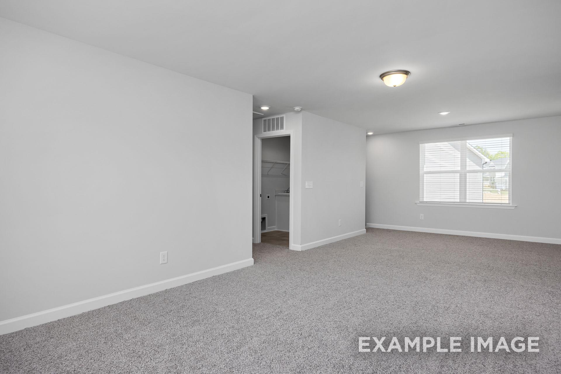 Spacious upper-floor master bedroom in The Preston B with gray carpet, walk-in closet, large window, and recessed lighting