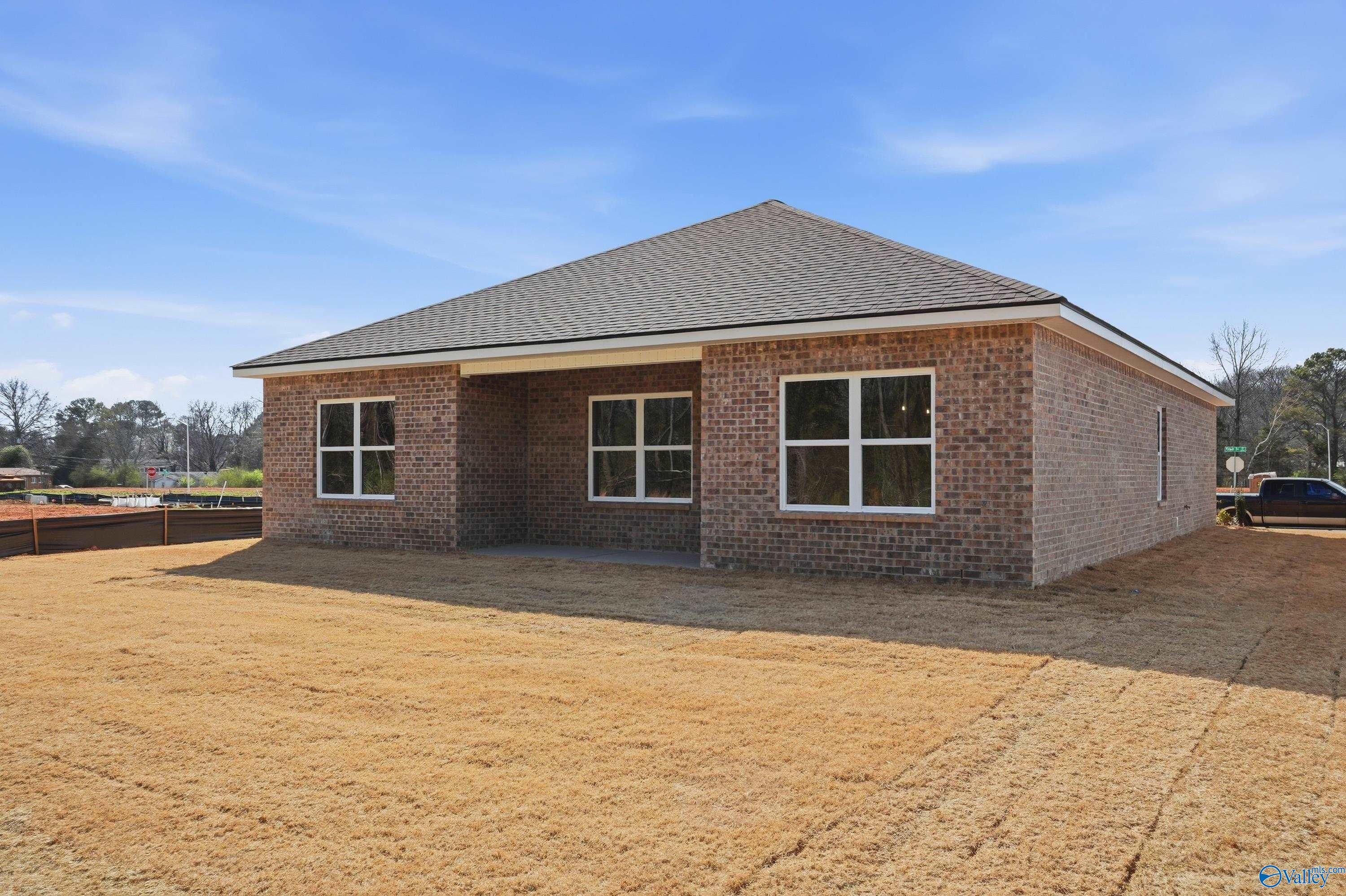 Single-story brick home with gabled roof, covered entry, and large windows in Spragins Cove, Huntsville, Alabama - Davidson Homes The Asheville