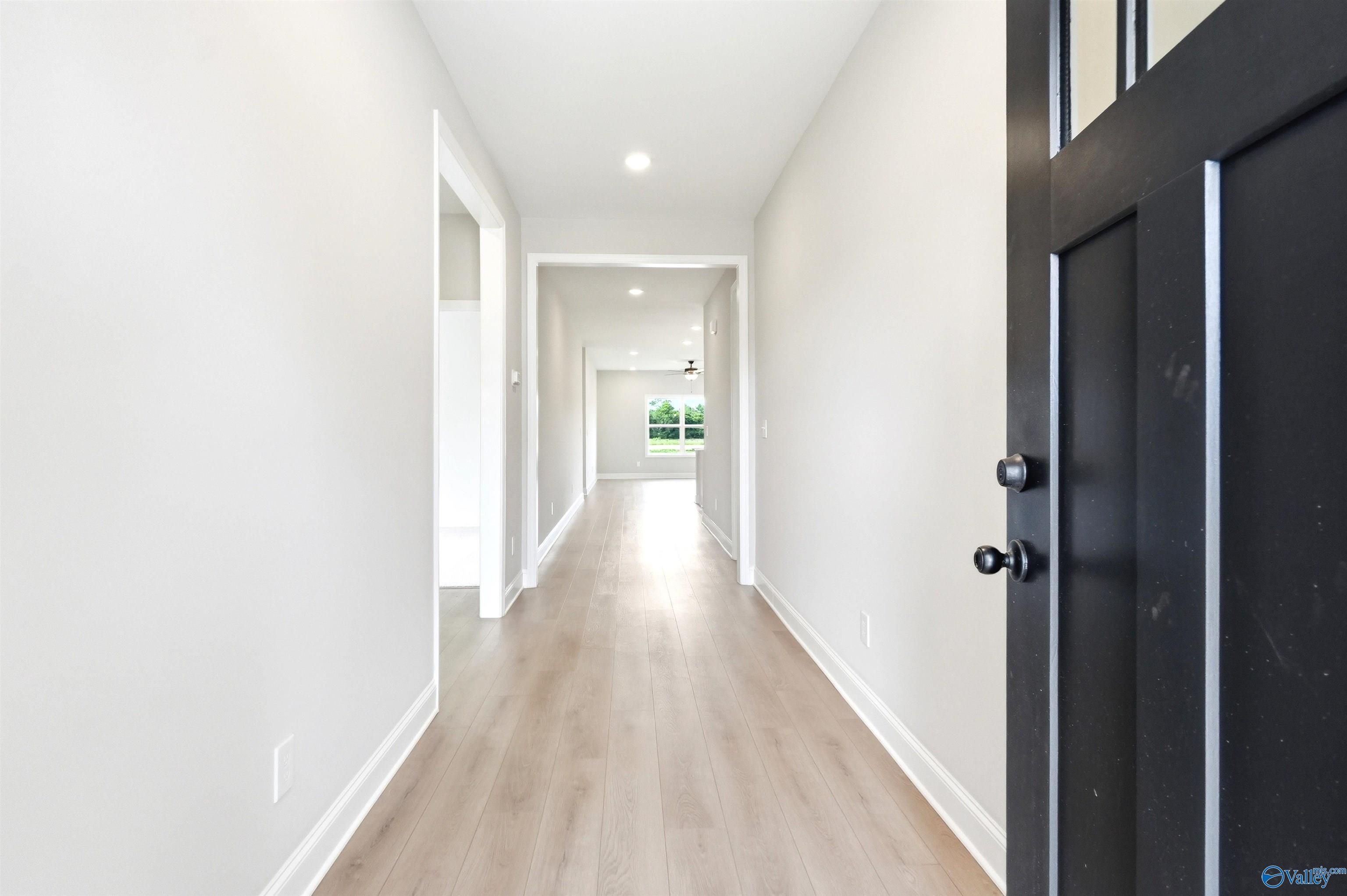 Bright foyer and hallway with luxury vinyl plank flooring in The Daphne F floor plan at Berry Cove, New Market, Alabama.