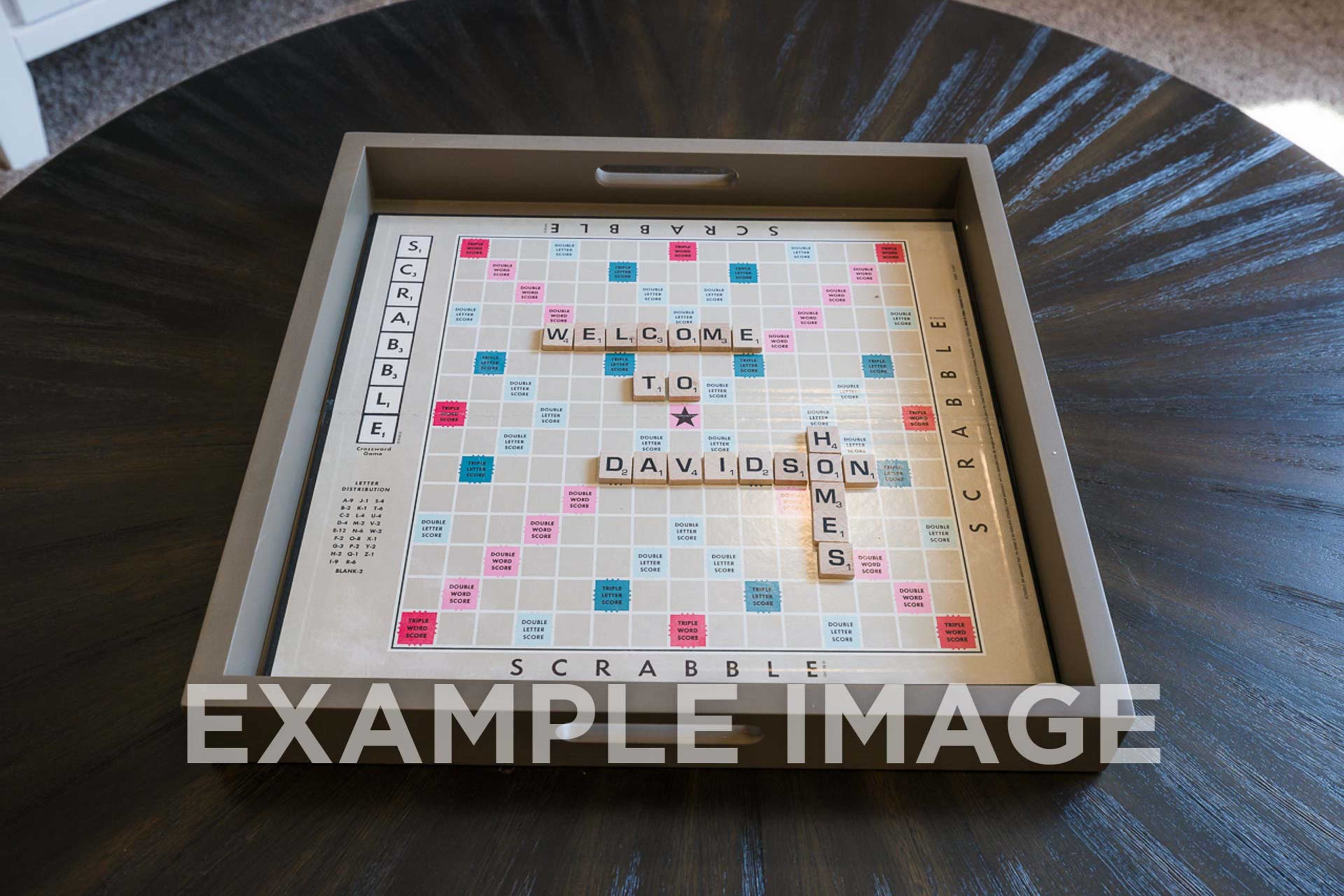 Scrabble board spelling "Welcome to Davidson Homes" on wooden table, promoting Angier NC custom home designs