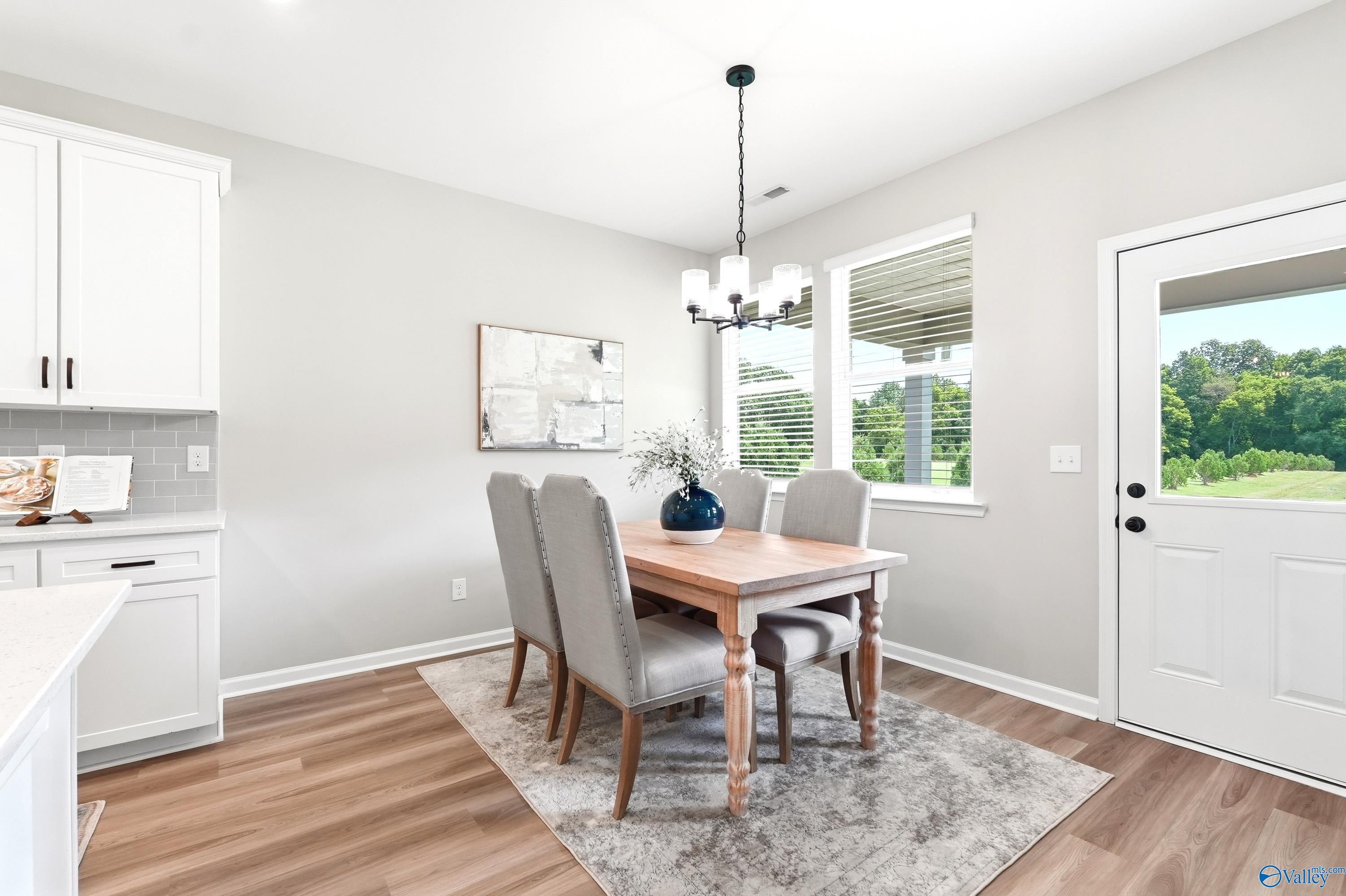 Bright dining area with wood table and upholstered chairs in The Dorado floor plan at Riverton Preserve, Huntsville, AL.