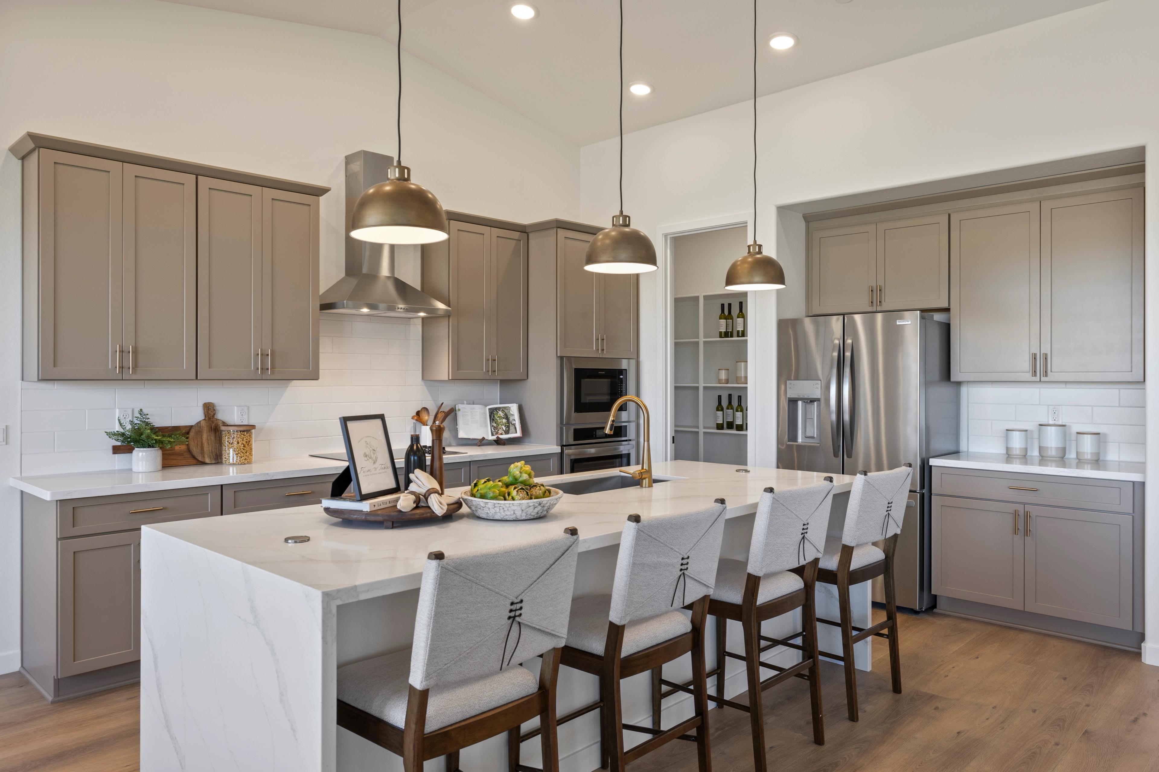 Modern kitchen with quartz island, gray cabinets, stainless appliances and pendant lights at Vineyards at Cottonwood in Cottonwood AZ