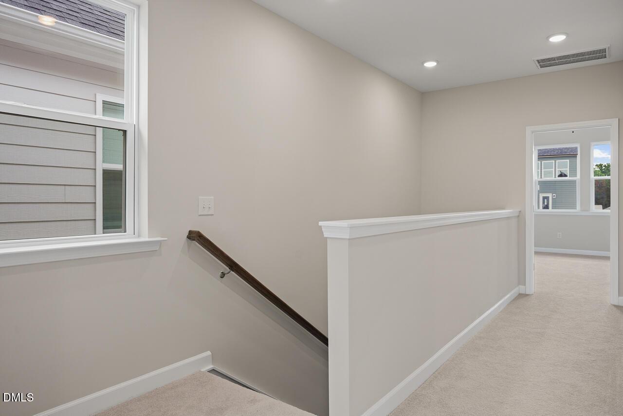 Bright upstairs landing with carpeted flooring in The Alexander C floor plan by Davidson Homes in Forestville Yard.