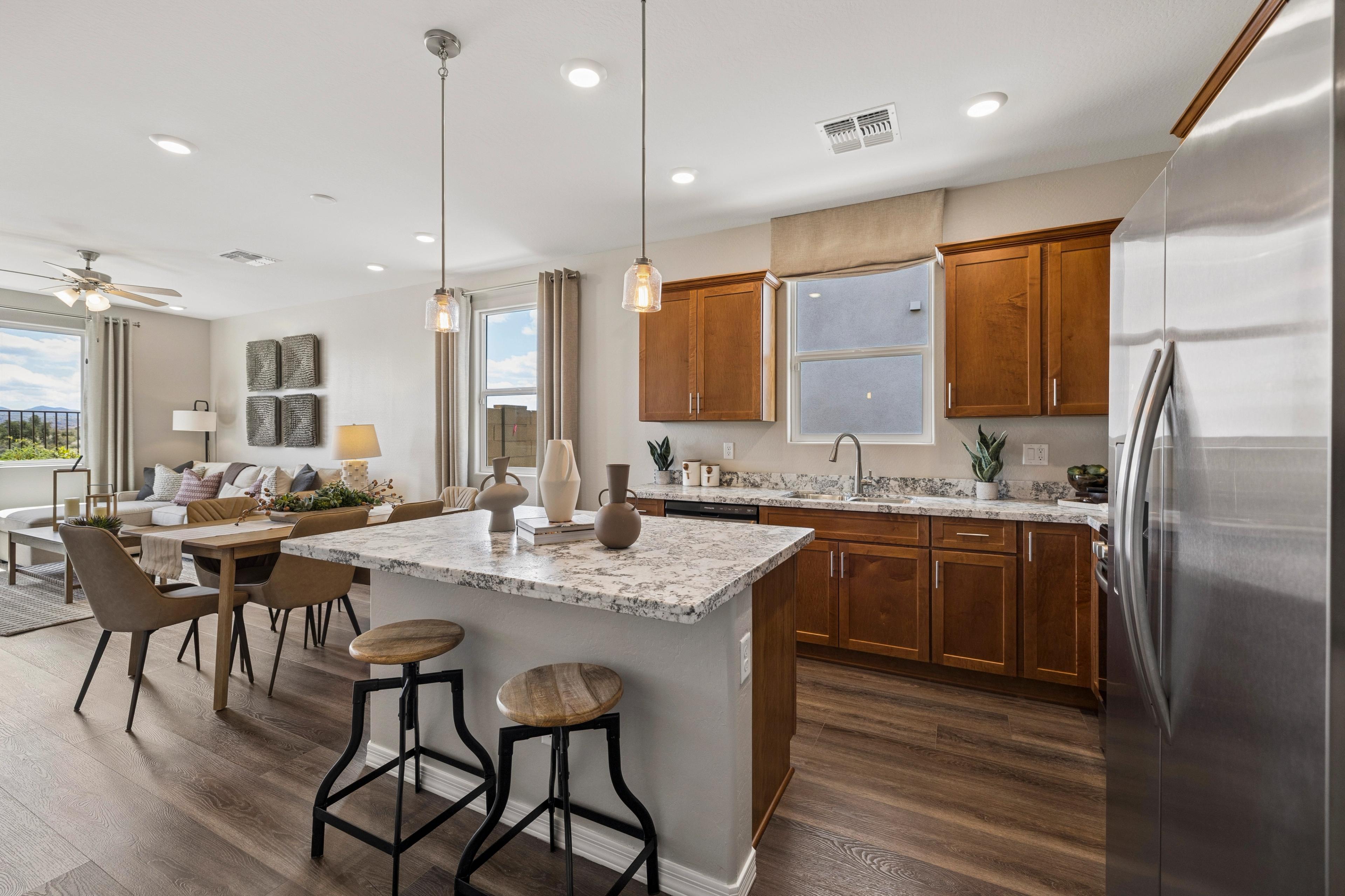 Spacious white kitchen at Senator Cottages in Prescott AZ with quartz island, bar stools, pendant lights, and stainless appliances