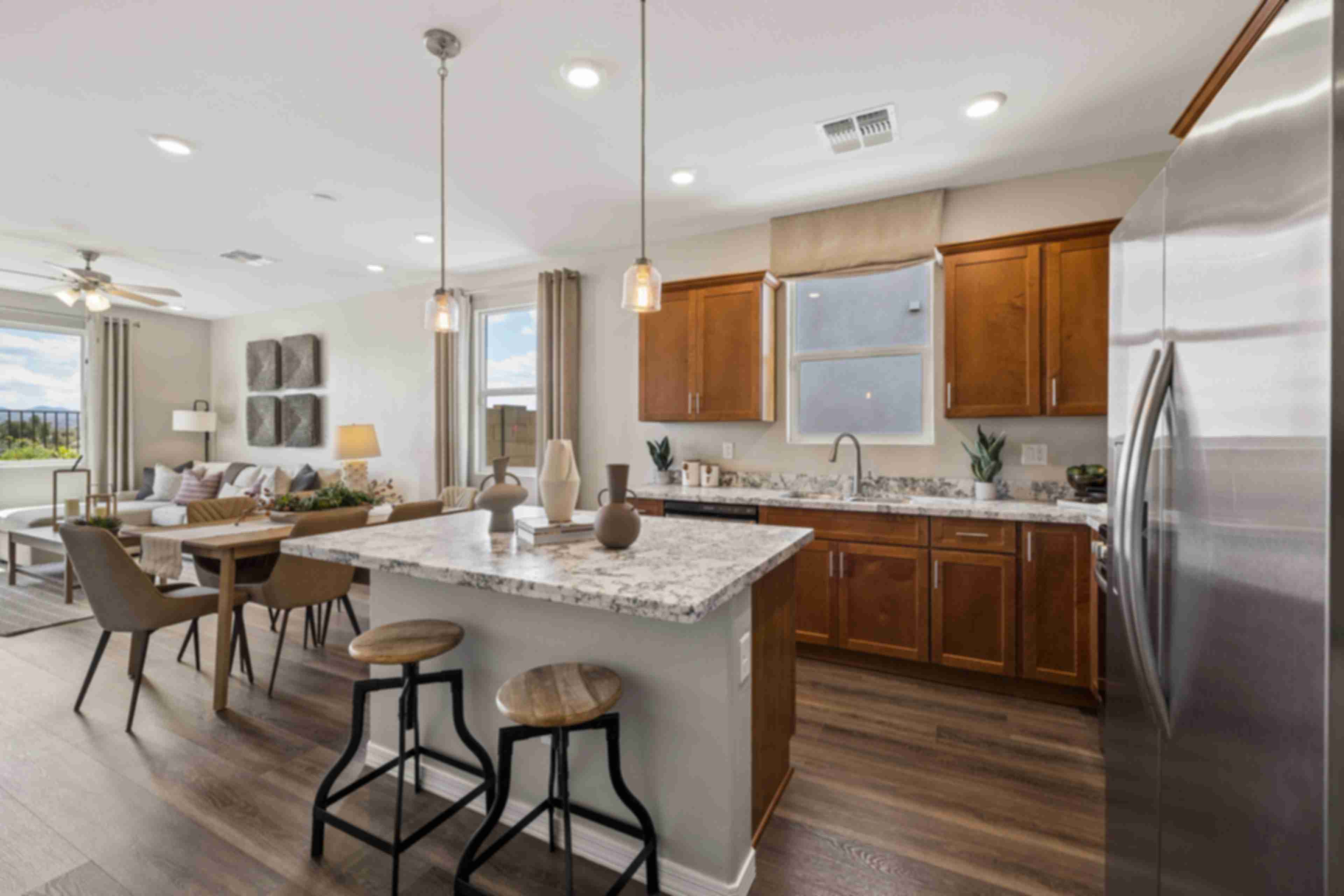 Spacious white kitchen at Senator Cottages in Prescott AZ with quartz island, bar stools, pendant lights, and stainless appliances