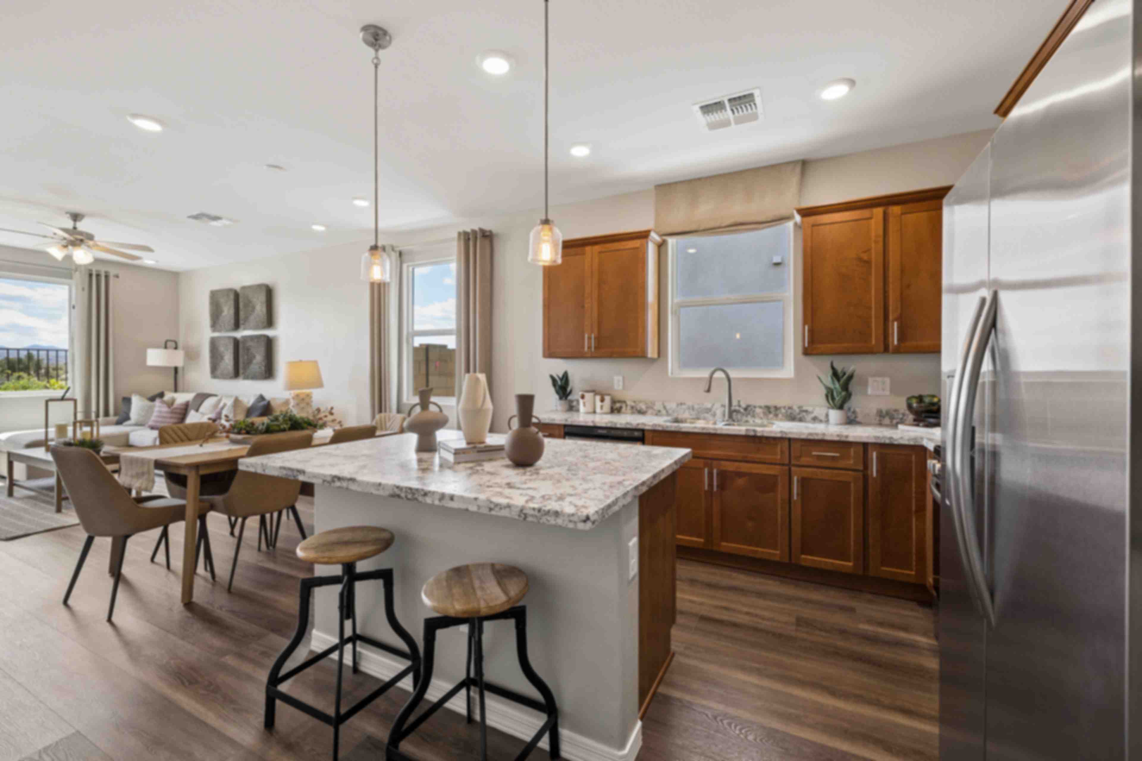 Spacious white kitchen at Senator Cottages in Prescott AZ with quartz island, bar stools, pendant lights, and stainless appliances