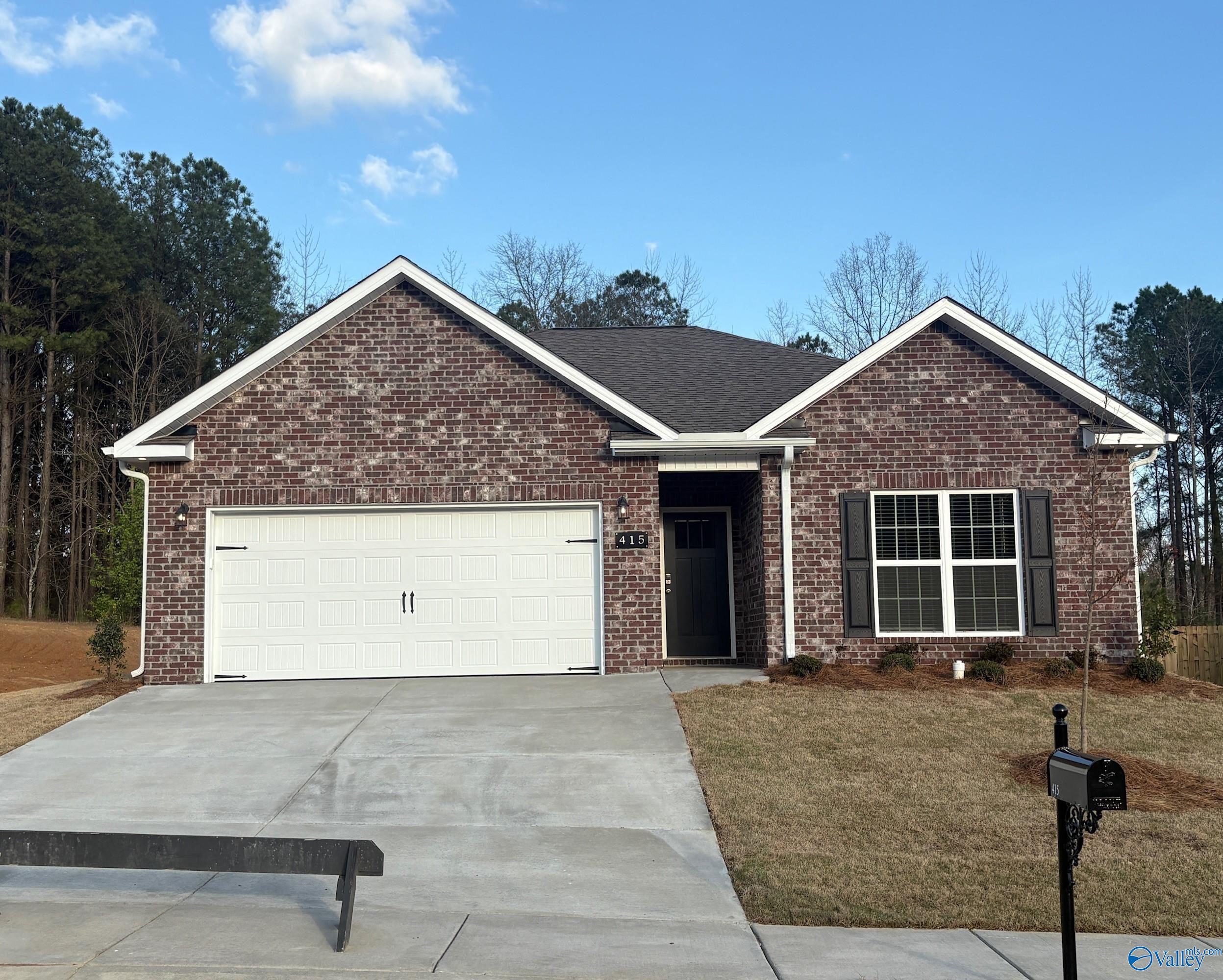 Single-story brick ranch home with 2-car garage, white shutters, and driveway in The Highlands, Arab, Alabama by Davidson Homes