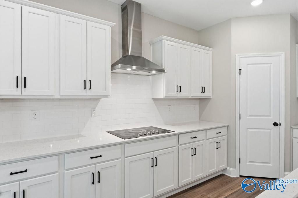 Modern kitchen with white cabinets, subway tile backsplash, and stainless steel range in The Rockford floor plan, Hartselle.