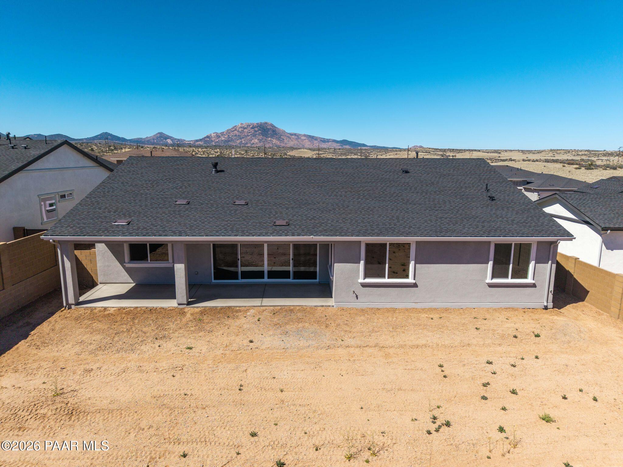 Covered back patio with sliding doors and expansive dirt yard overlooking mountains in Davidson Homes The Monarch A, Prescott, Arizona