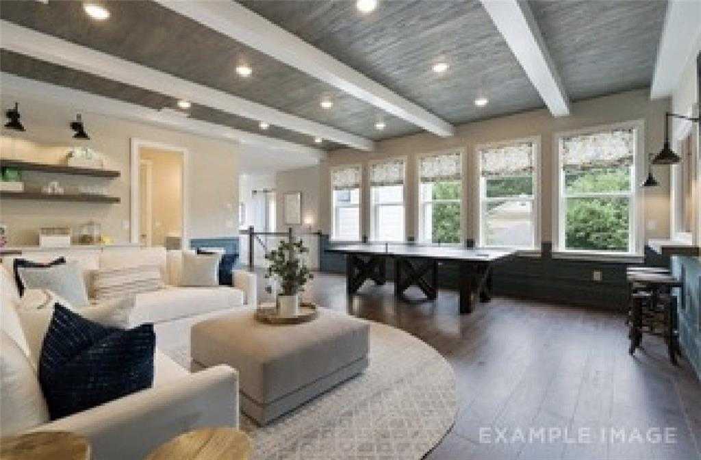 Spacious game room with pool table, coffered ceiling, bar, and sectional sofa in Davidson Homes The Seaside A, Woodstock, GA