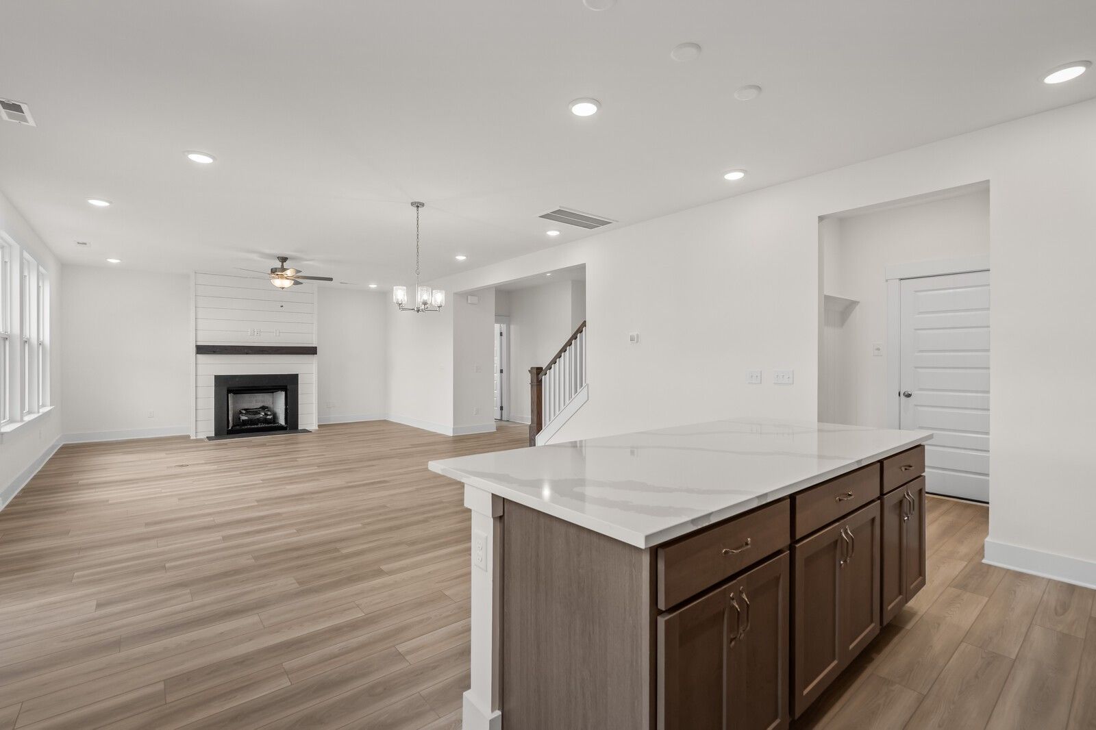 Open-concept living room with fireplace and kitchen island in The Henry C floor plan at Benders Cove, Mt. Juliet, Tennessee.