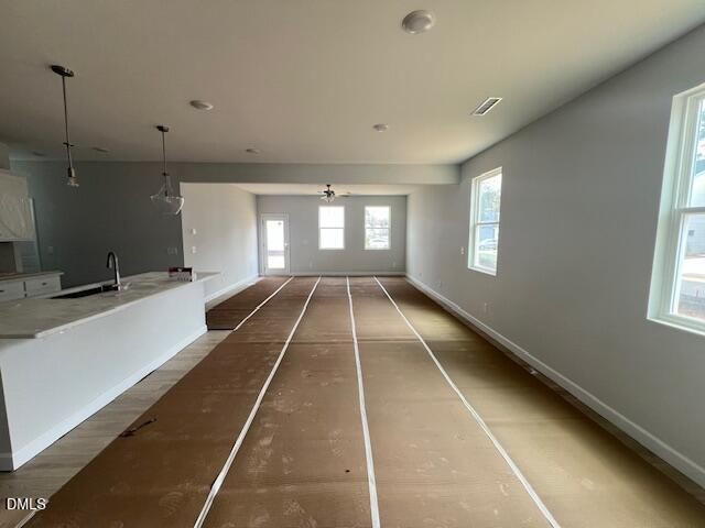 Open-concept kitchen-living area with white quartz island, pendant lights, and large windows in Davidson Homes Adalynn B, Lillington NC