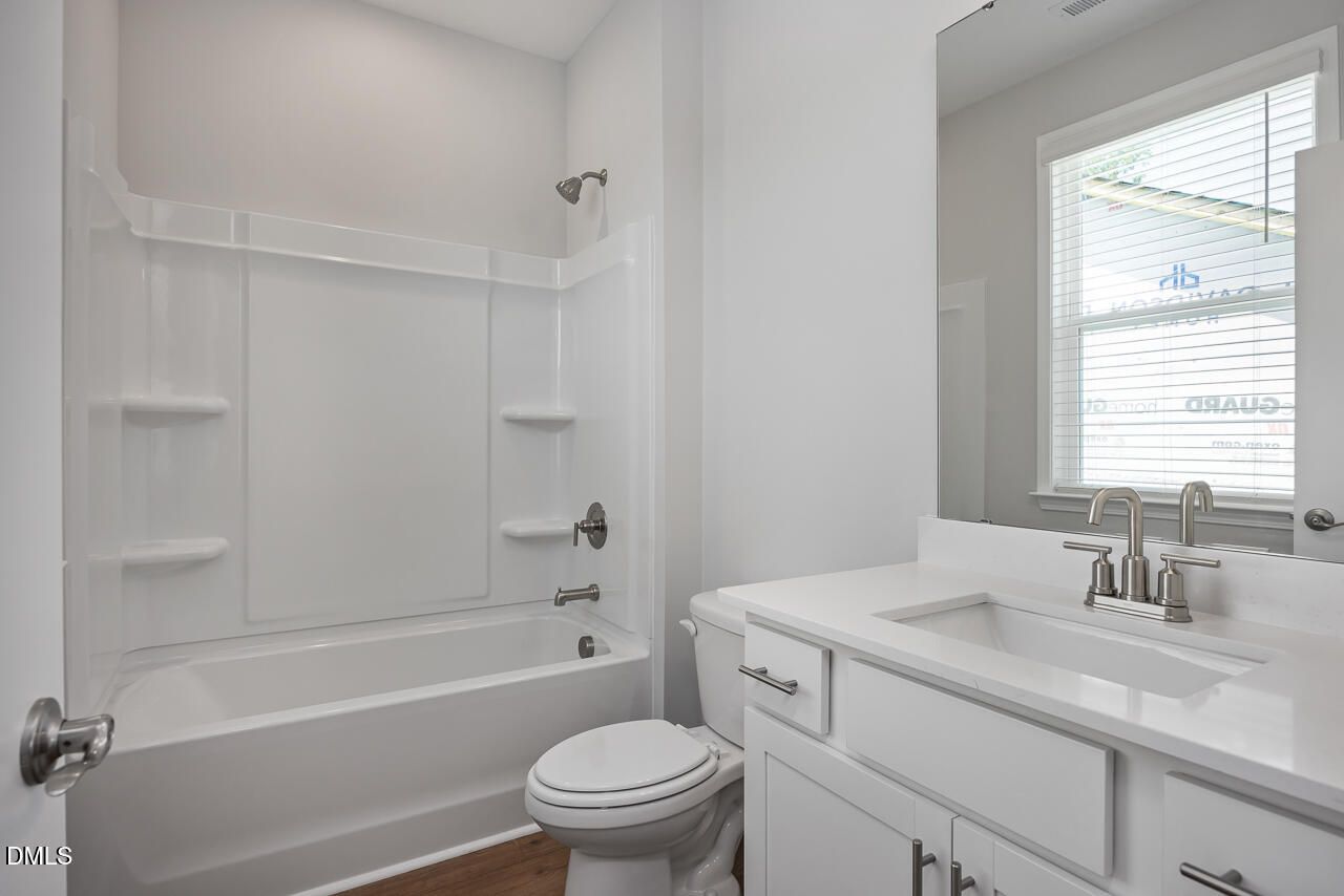 Modern bathroom with white vanity and tub-shower combo in The Ashport L plan at Sage on North Main, Wake Forest, NC.