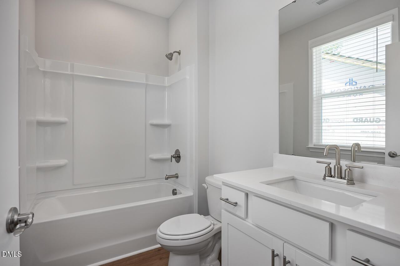 Modern bathroom with white vanity and tub-shower combo in The Ashport L plan at Sage on North Main, Wake Forest, NC.