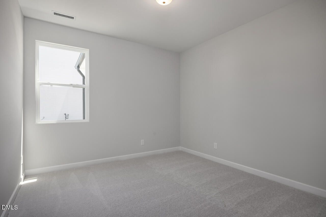 Bright, spacious bedroom with neutral carpet in The Adalynn B floor plan at Gregory Village in Lillington, North Carolina.