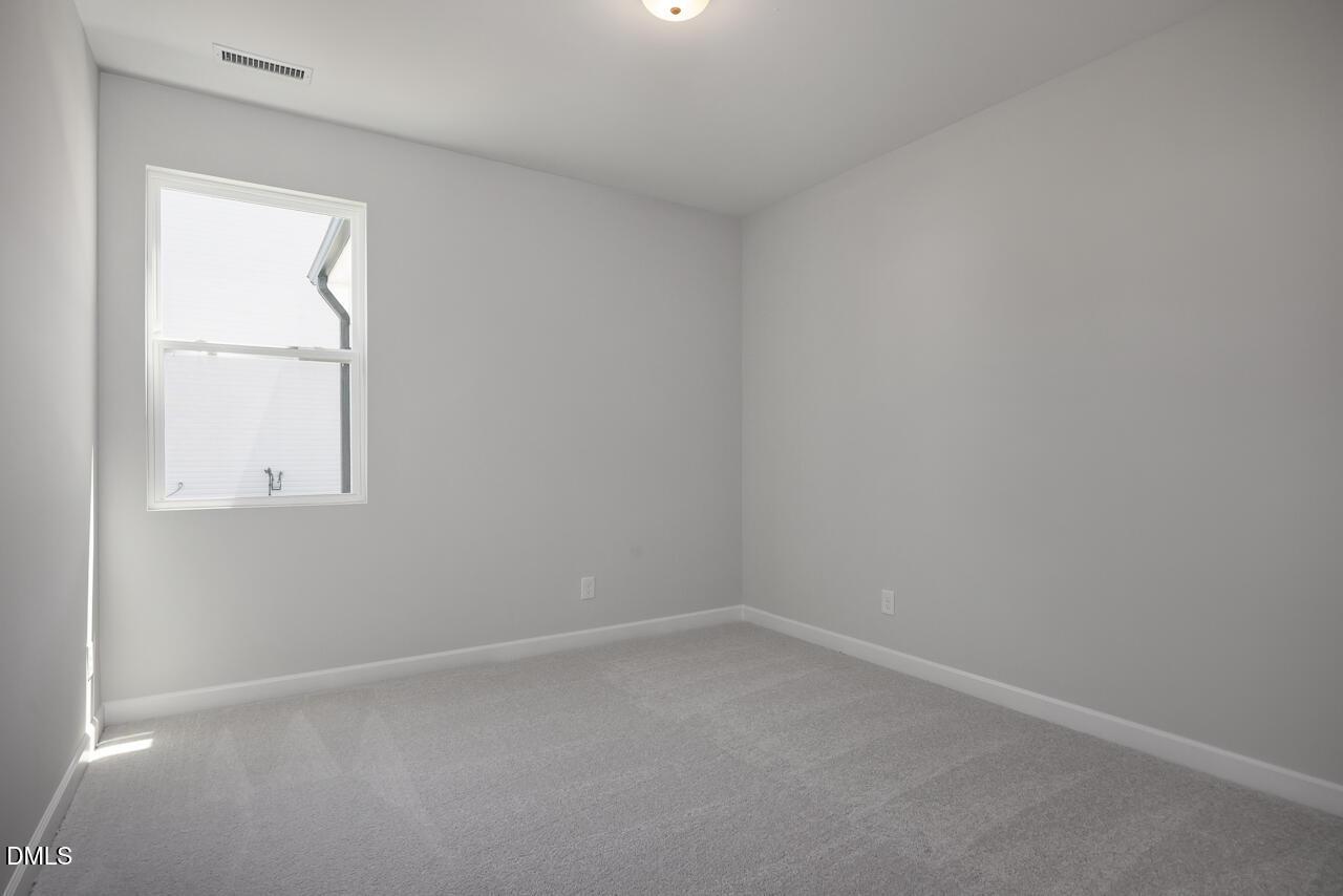 Bright, spacious bedroom with neutral carpet in The Adalynn B floor plan at Gregory Village in Lillington, North Carolina.