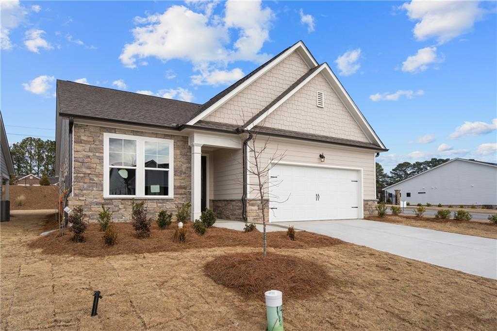 Modern 1-story Glenwood A home exterior with beige siding, stone accents, 2-car garage, and landscaped yard in Kelly Preserve, Loganville, GA