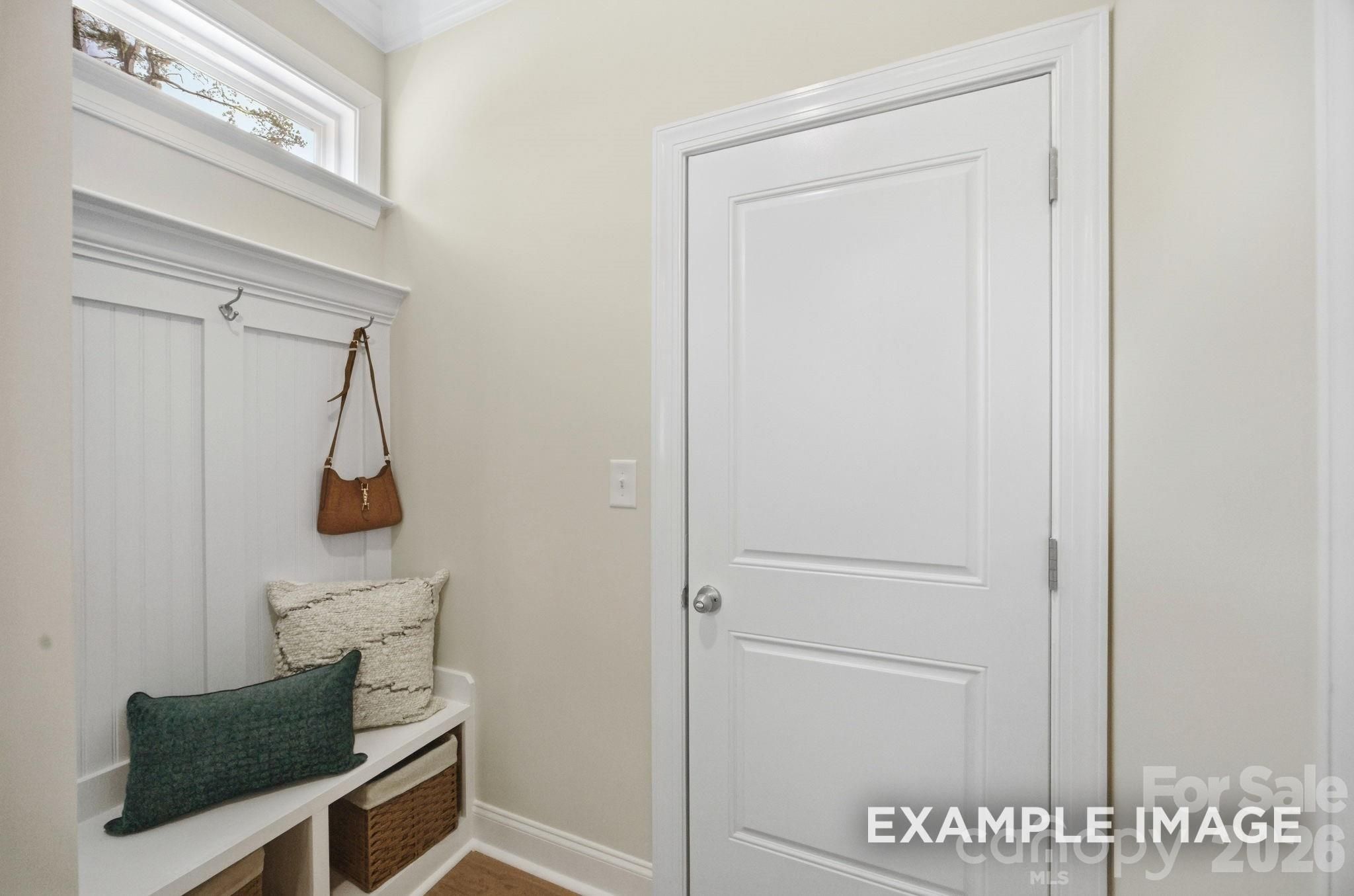 Mudroom drop zone with built-in bench, storage baskets, and coat hooks in The Hickory B II plan, Windgate, Mooresville, NC.
